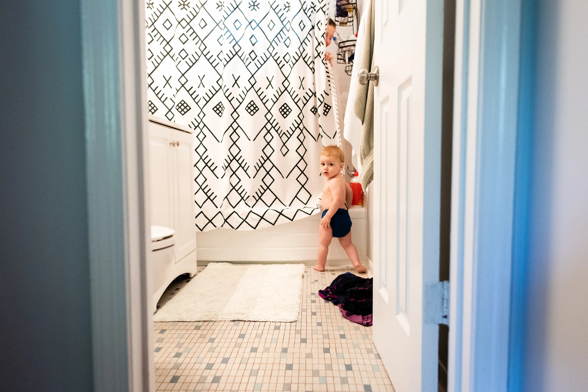 Toddler peeking in on mom in shower by Family Photographer Nicole Sanchez