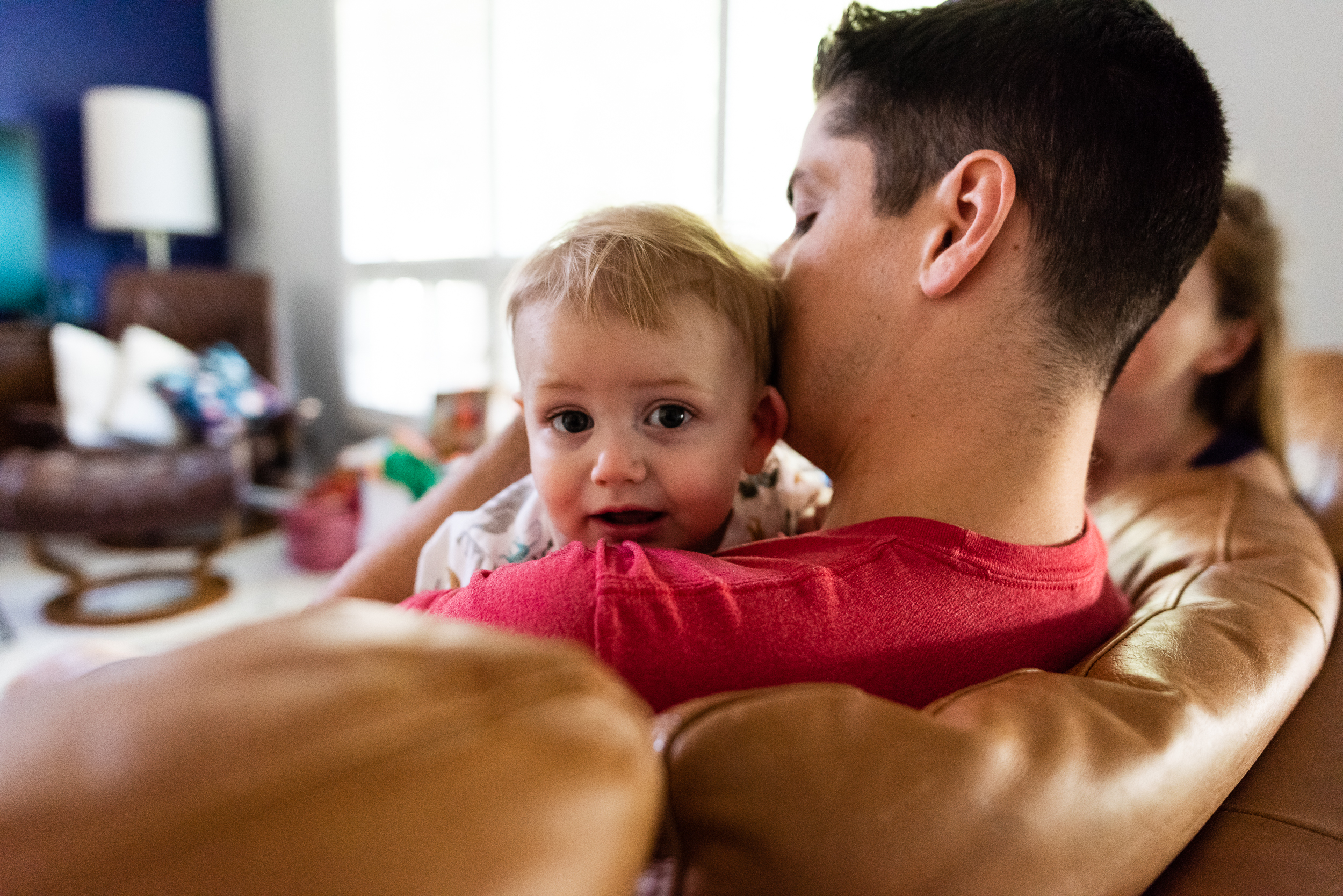 father holding son on couch at home by family photographer nicole sanchez