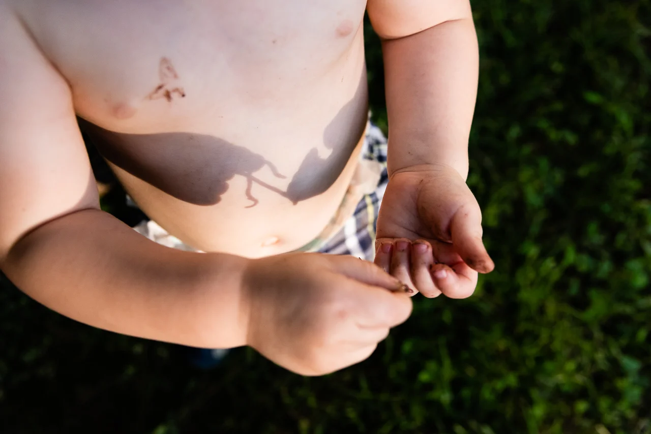 Boy holding worm in backyard by Northern Virginia Family Photographer Nicole Sanchez