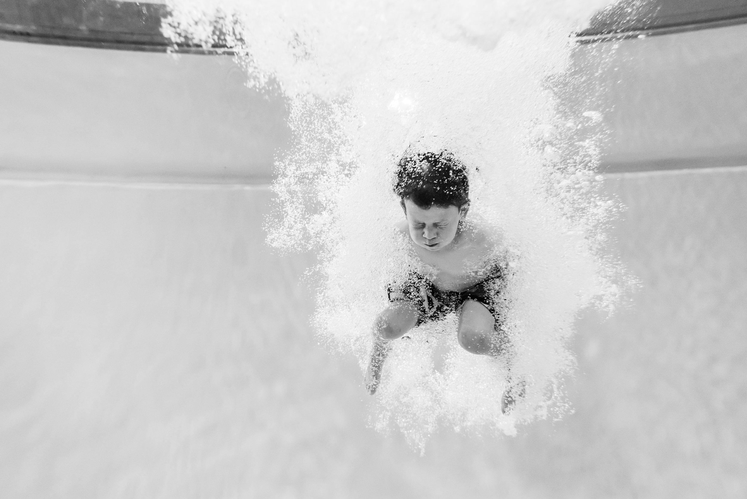 Boy jumping underwater at pool by Northern Virginia Family Photographer Nicole Sanchez