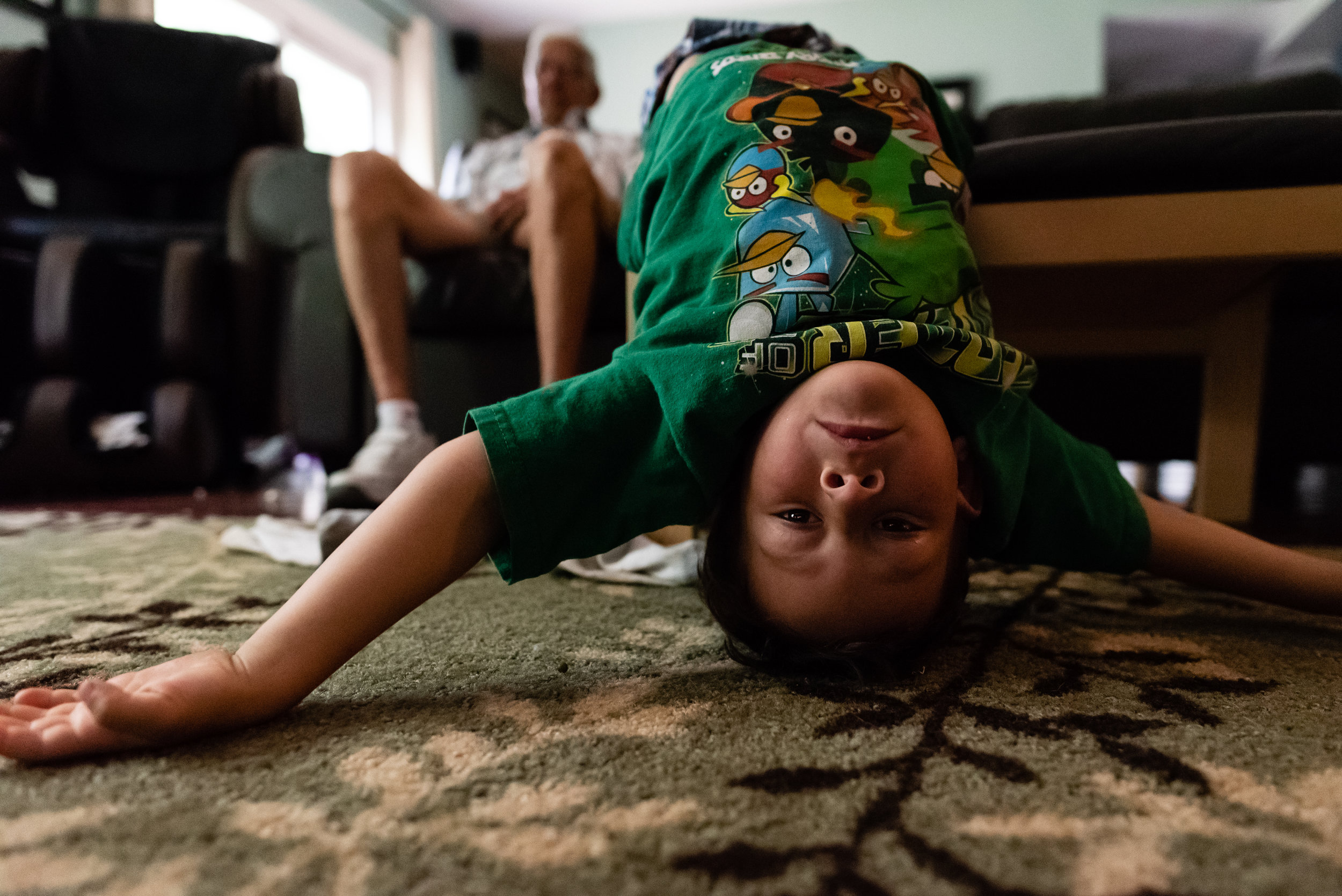 Boy hanging upside down off couch by Northern Virginia Family Photographer Nicole Sanchez