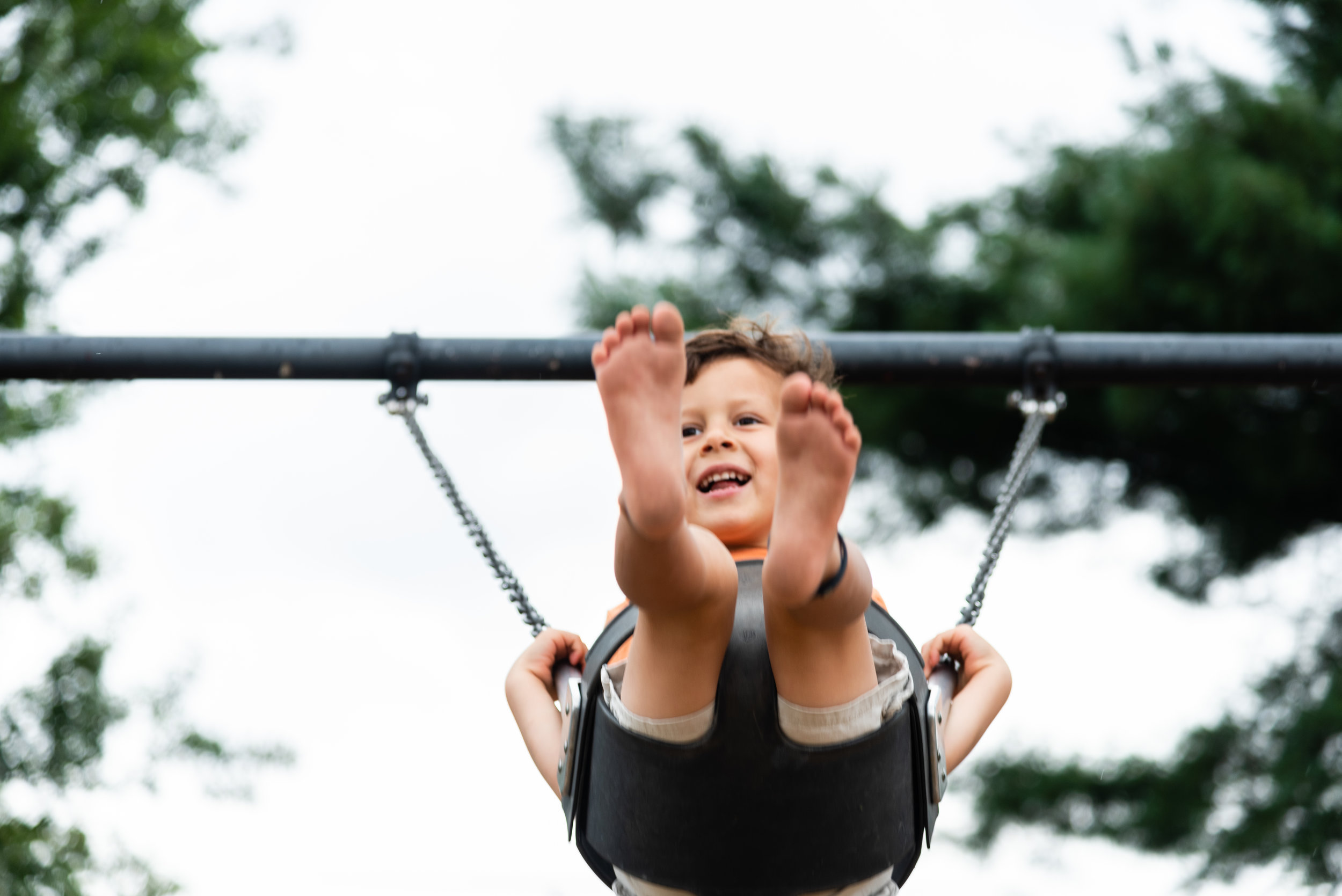 Boy swinging at Windmill Hill Park in Alexandria by Northern Virginia Family Photographer Nicole Sanchez