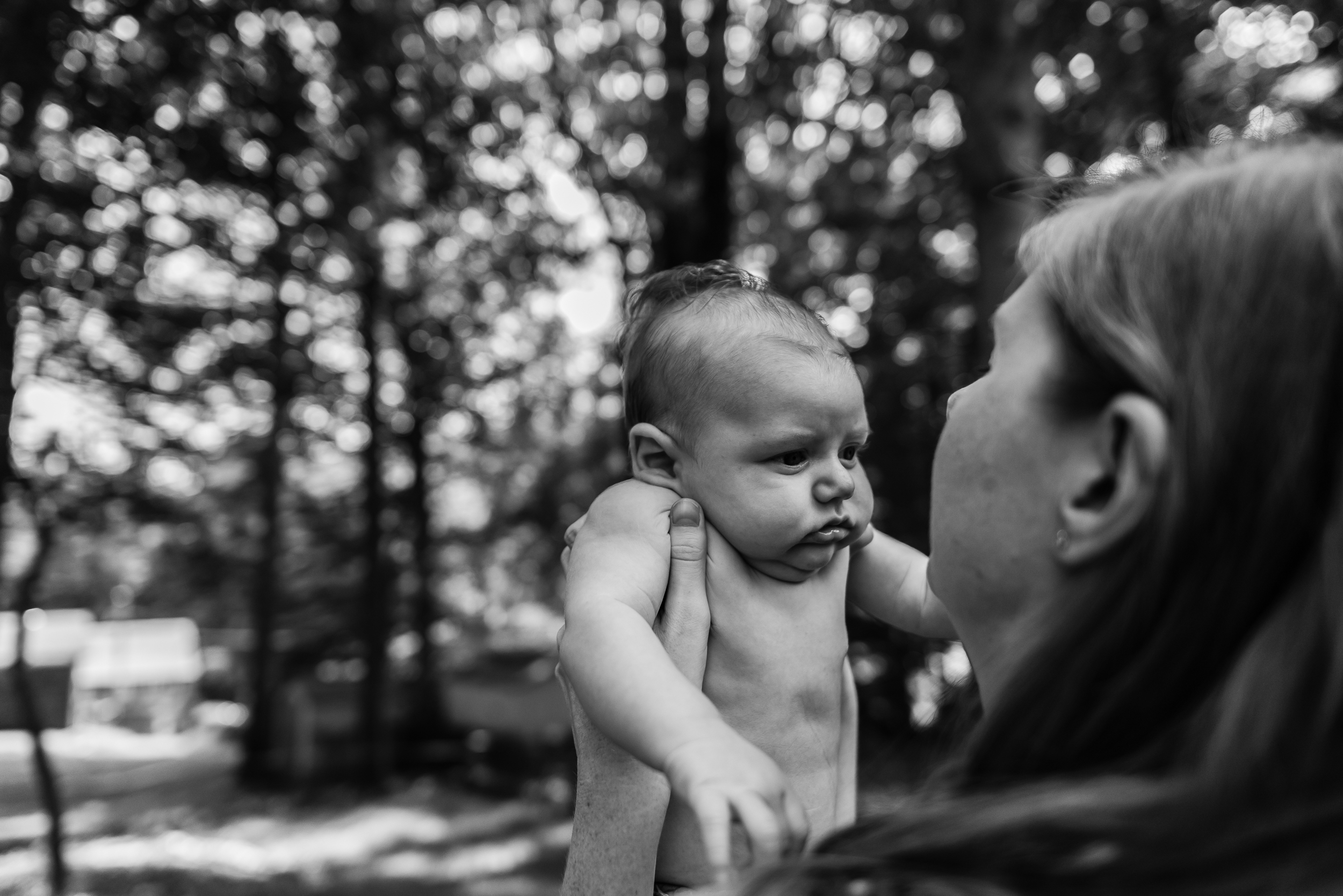Mom holding new baby outside by Northern Virginia Newborn Photographer Nicole Sanchez