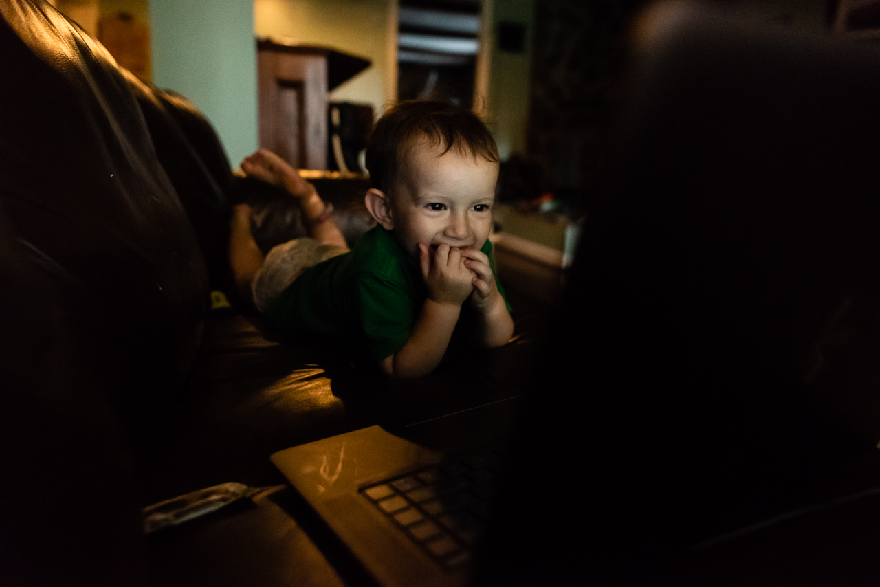 Toddler giggling while watching a family film by Northern Virginia Family Photographer Nicole Sanchez