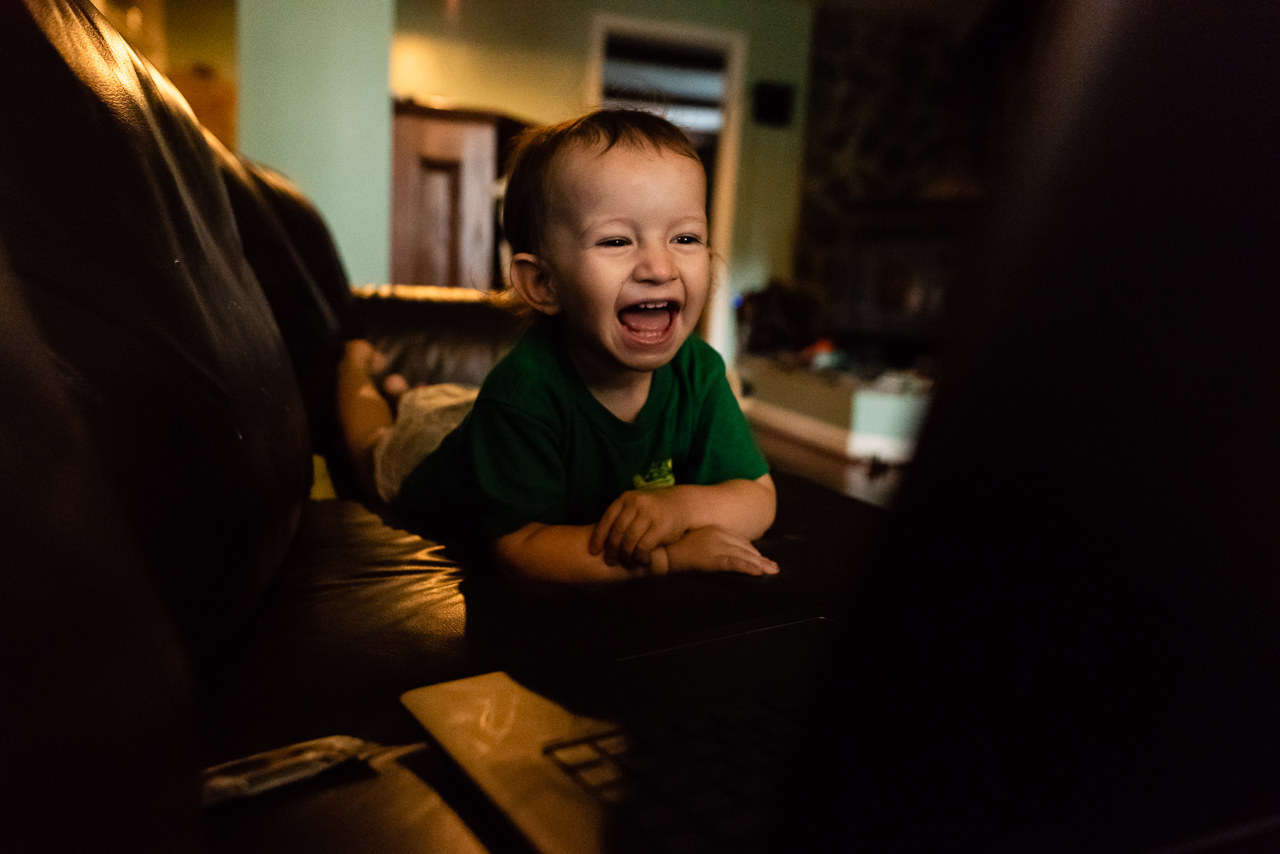 Baby laughing while watching his family film by Northern Virginia Family Photographer Nicole Sanchez