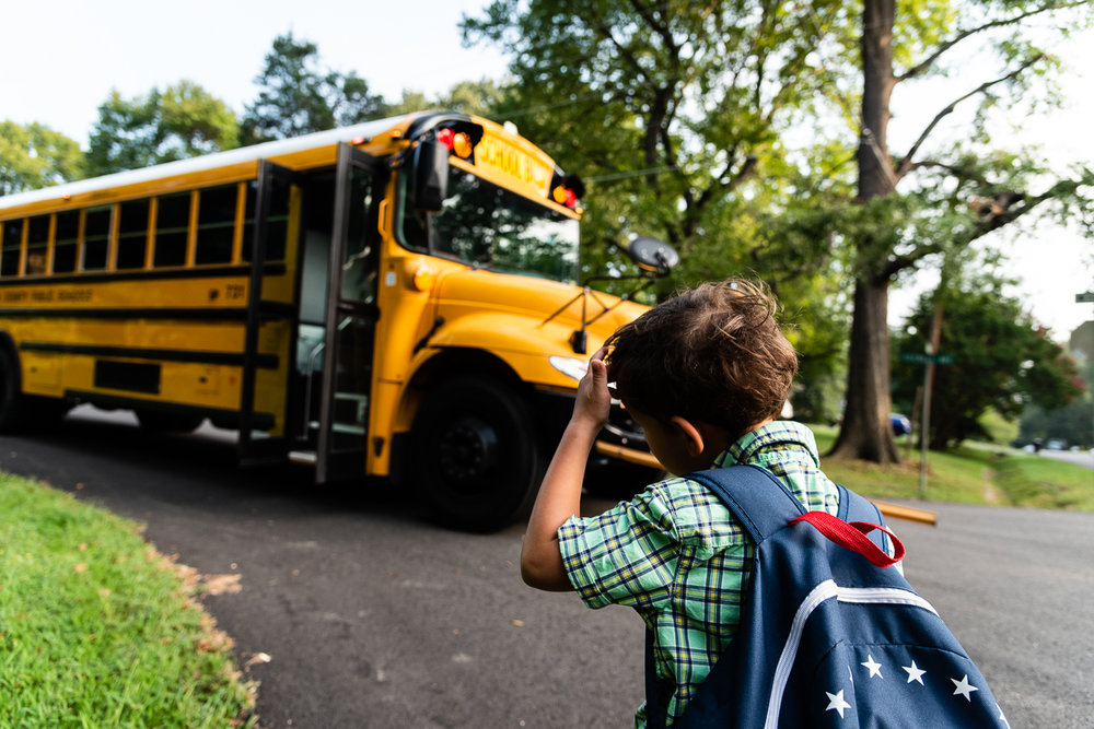 Kindergartner anxiously waiting for school bus in Northern Virginia by Family Photographer Nicole Sanchez