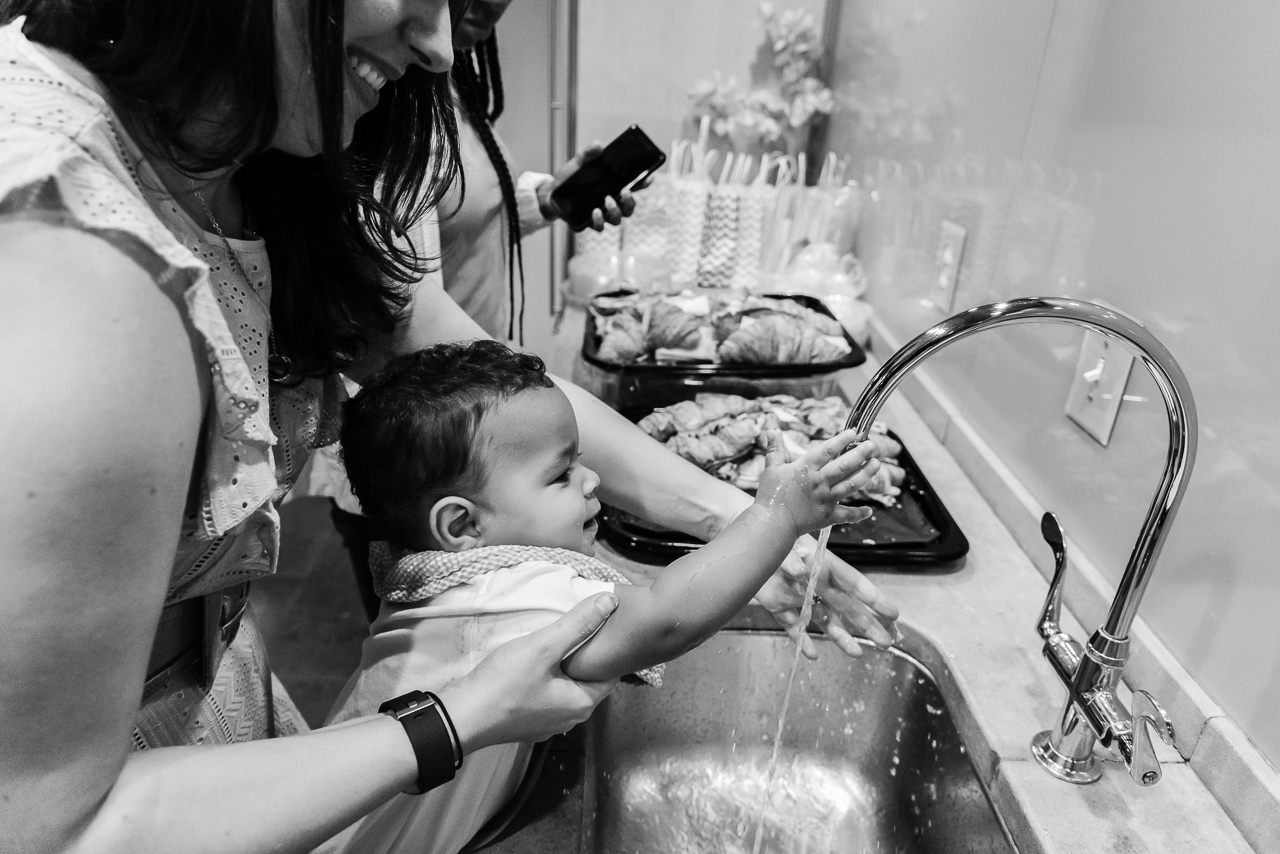 Mom washing cake off baby's hands 