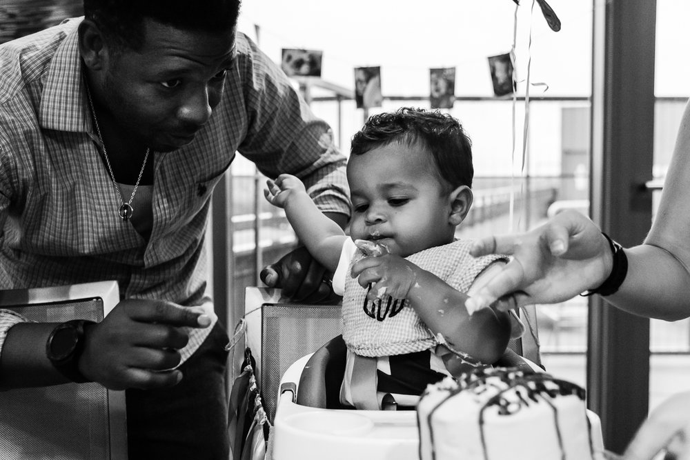 Dad helping baby eat birthday cake by Northern Virginia Family Photographer Nicole Sanchez