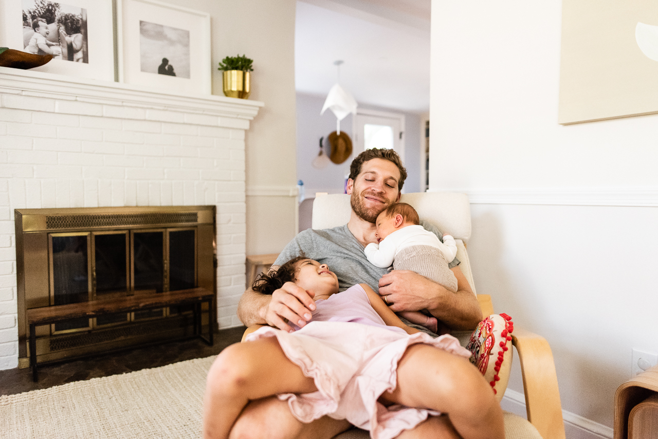 Father holding newborn and older daughter by Northern Virginia Family Photographer Nicole Sanchez