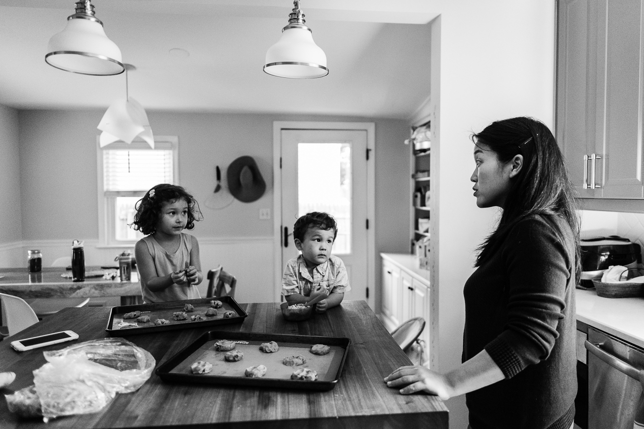 Mom at kitchen island giving baking instructions to son and daughter