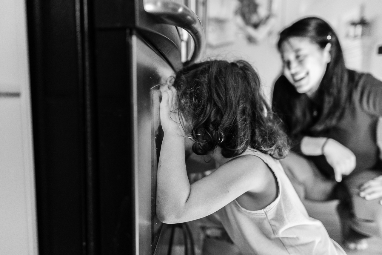 Mom smiling while watching kids wait for cookies to come out of oven by Northern Virginia Family Photographer Nicole Sanchez