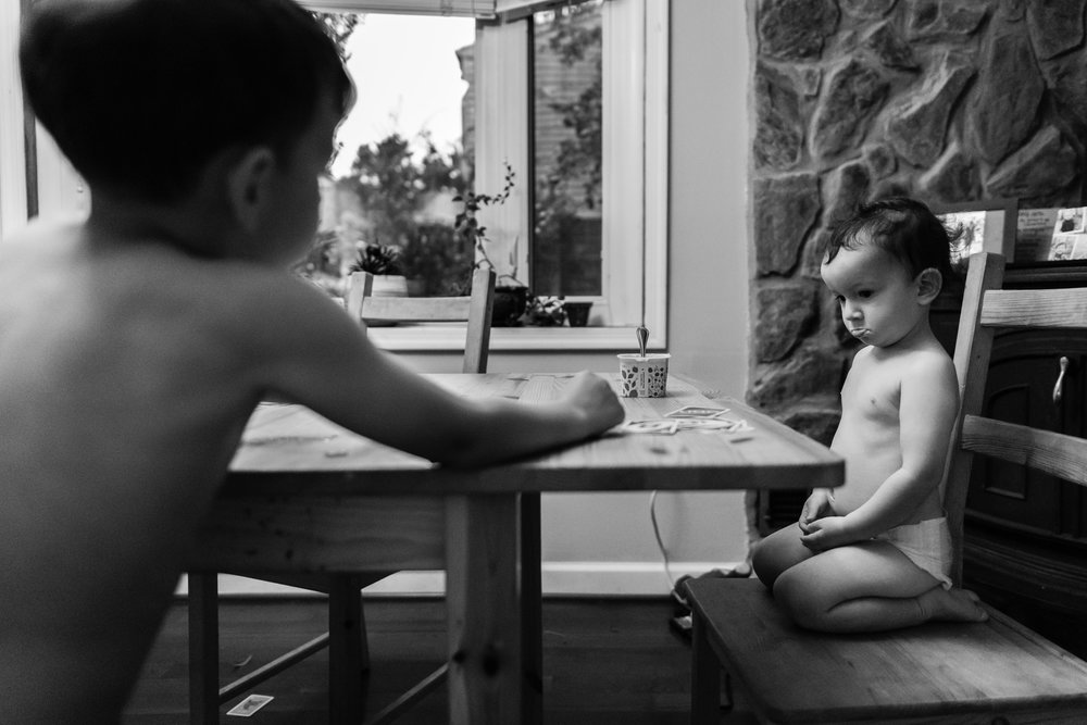 Little boy pouting at big brother while playing Uno by Family Photographer Nicole Sanchez