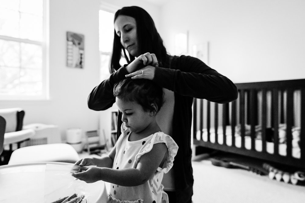 Mother putting daughter's hair in ponytail