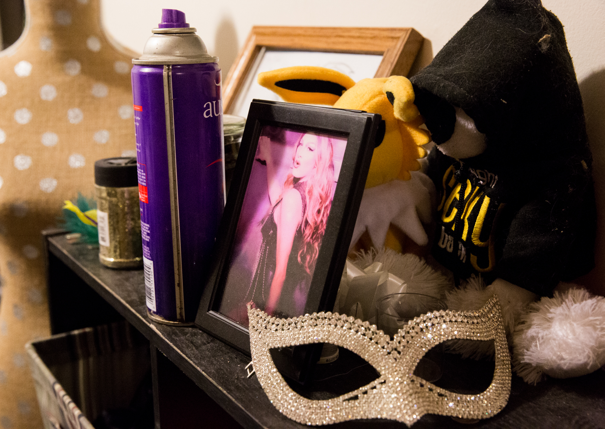 The dresser in Mark's drag room holds sentimental trinkets and mementos from past shows. The drag room is cluttered with things that Mark has collected throughout his five years of being a drag performer. 