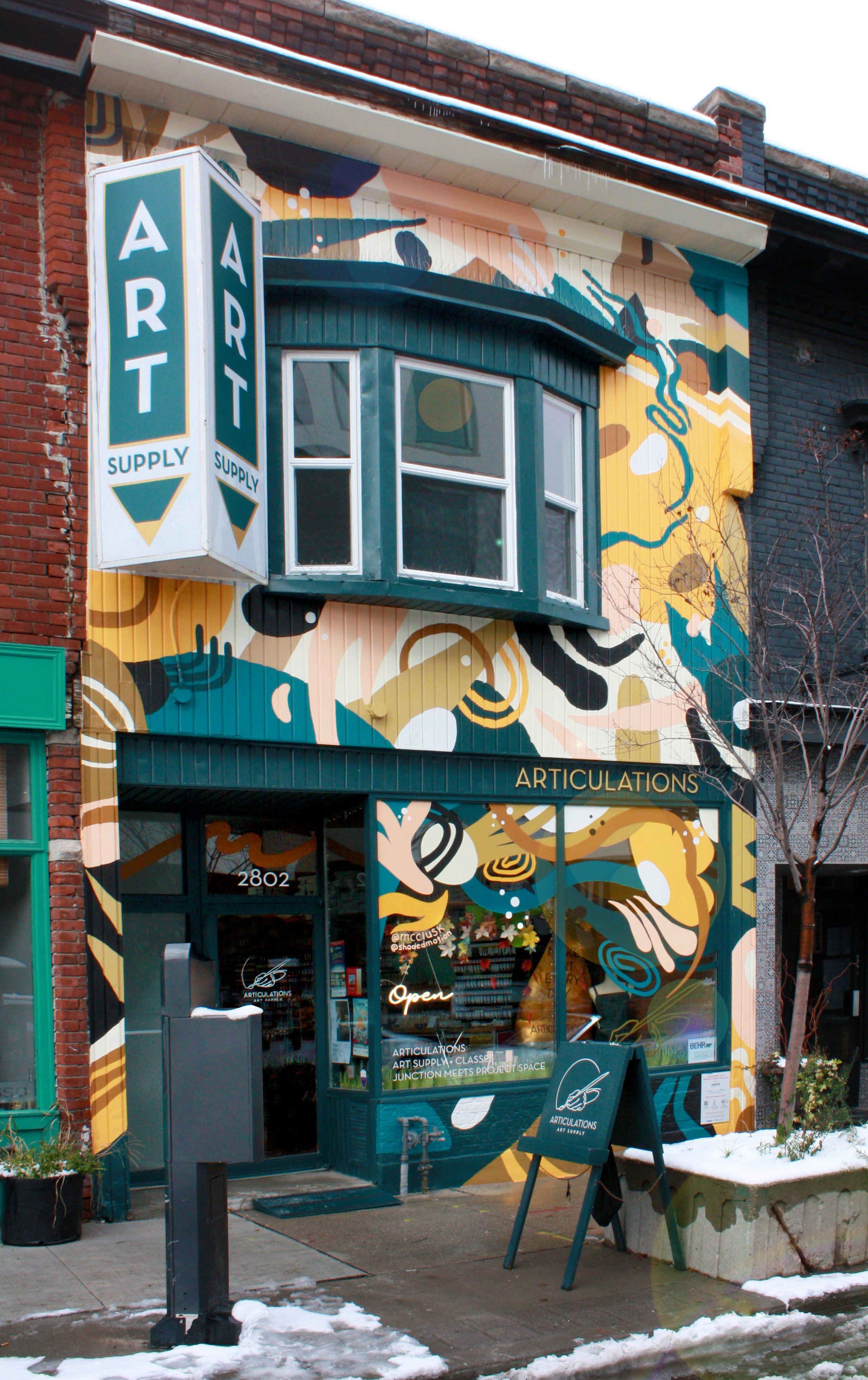   A photo of the art store “Articulations”. Erin painted the facade in a mural of fun swirling abstract shapes in muted tones.  