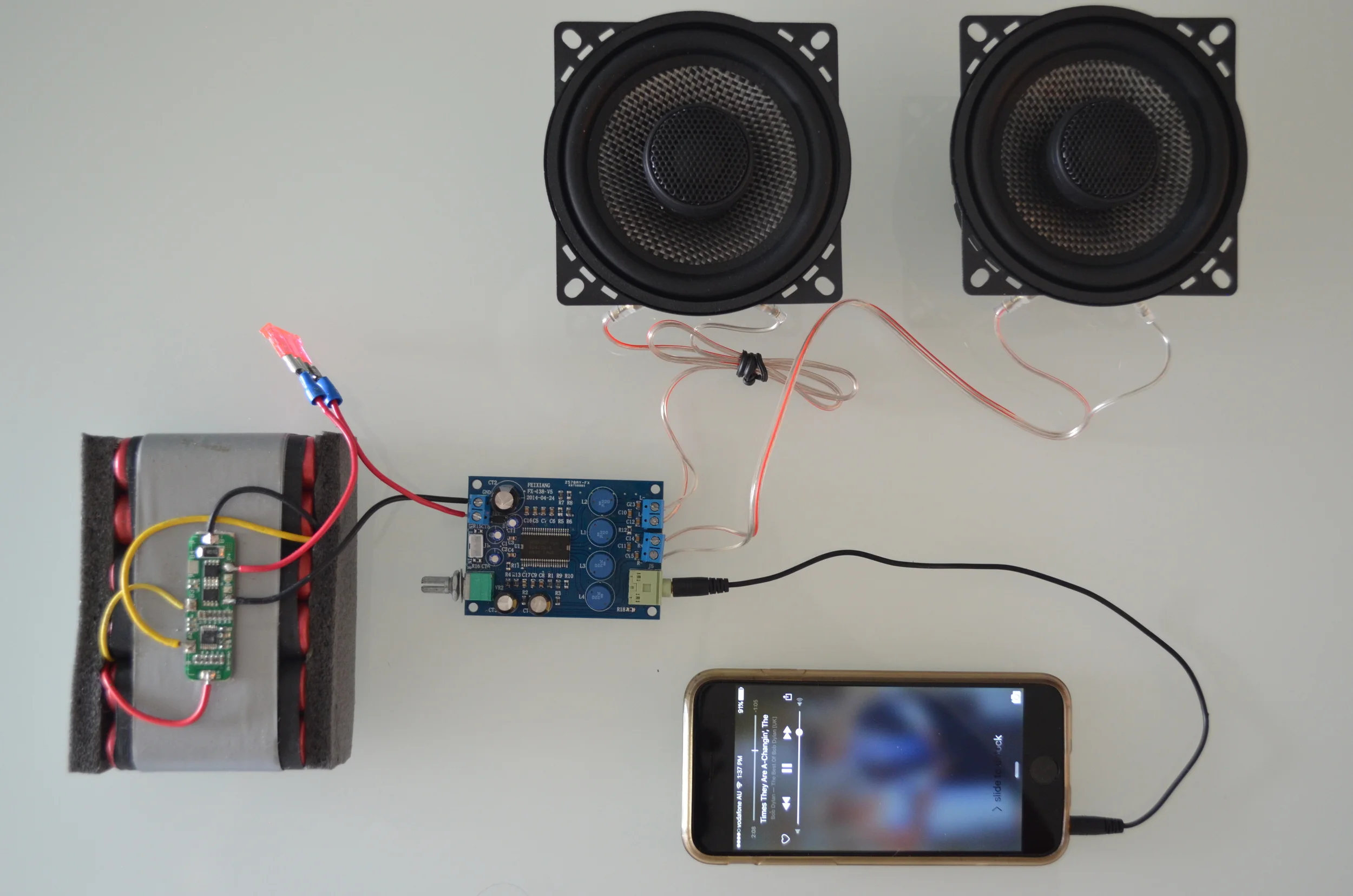 This photo shows the critical components of every audio system. The amplifier is receiving the audio signal from the iPhone. The amplifier 'boosts' the signal via the energy provided by the battery and sends the signal to the speakers. 