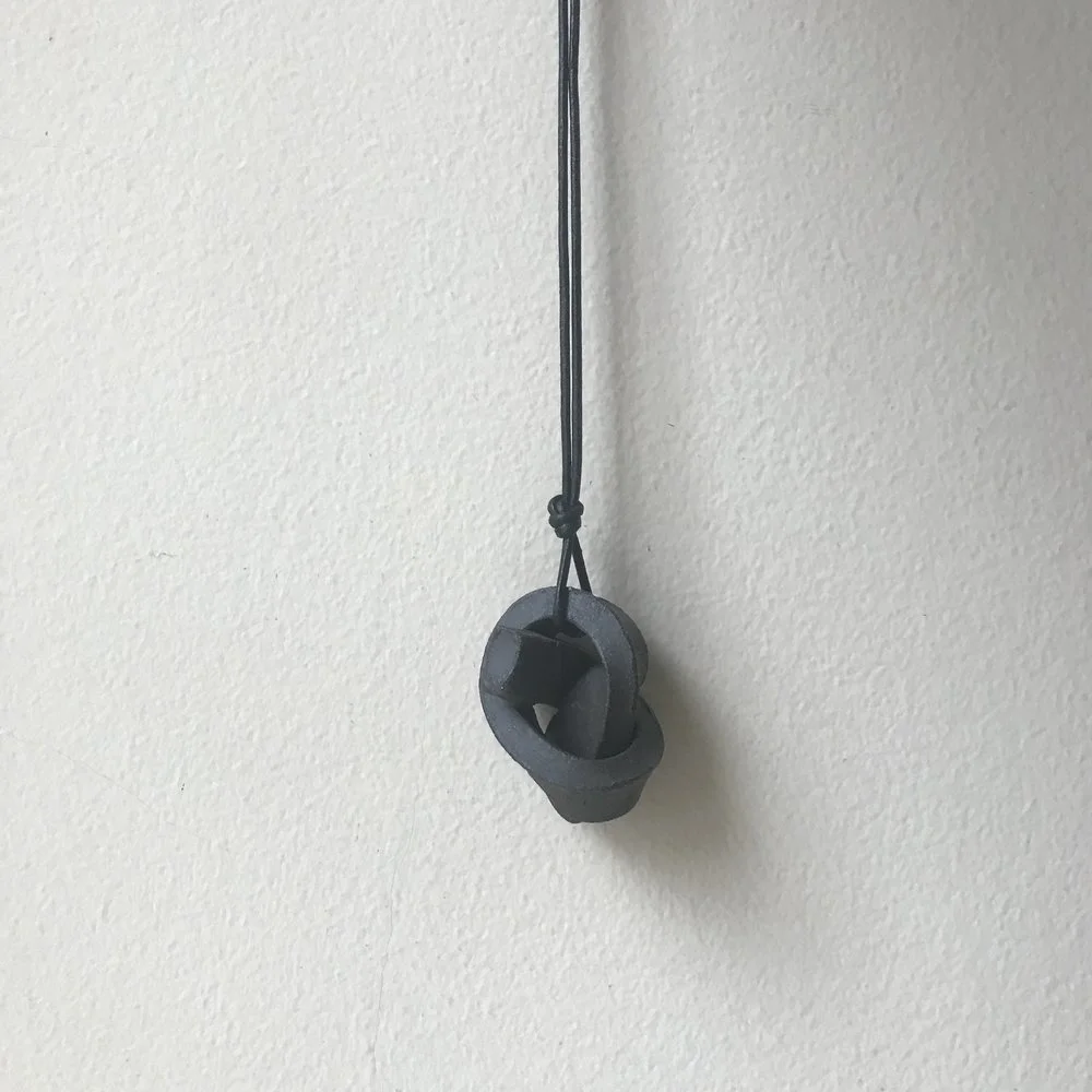 MINI UNION KNOT | CHARCOAL ceramic knot on leather cord approx. 2”L, 1.5”H, 1”W (varies) $20 Wholesale | $40 Retail
