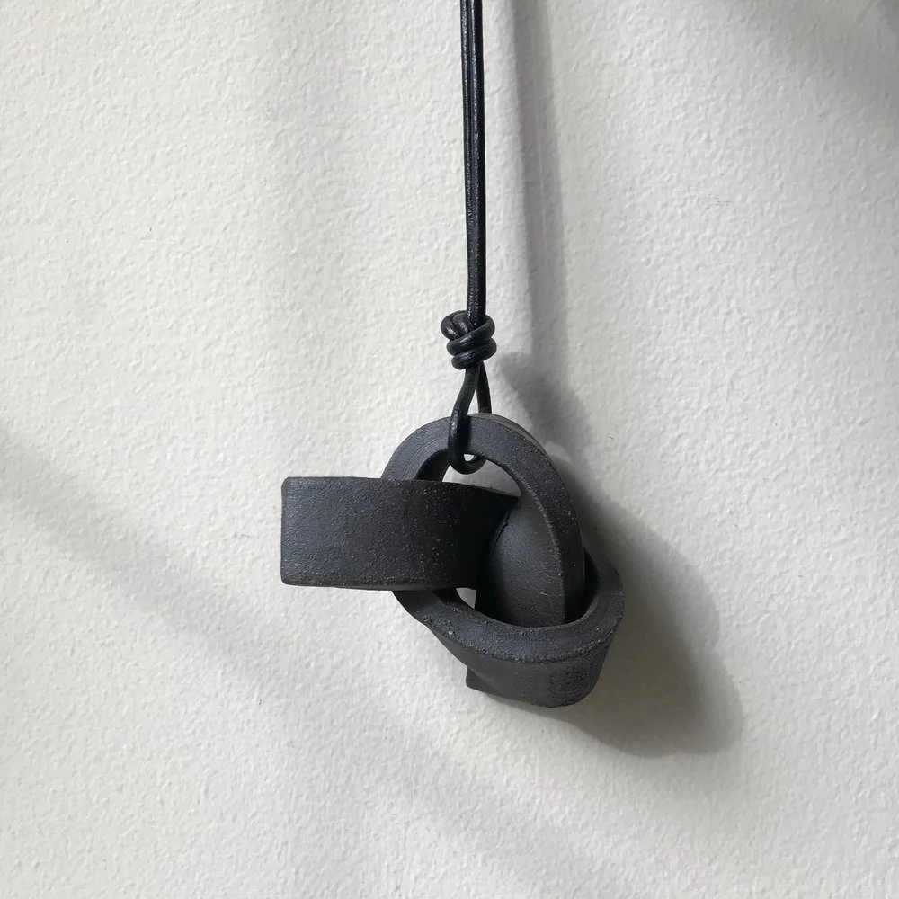 UNION KNOT | CHARCOAL ceramic knot on leather cord approx. 2.5"L, 4.5"H, 2"W (varies) $25 Wholesale | $50 Retail