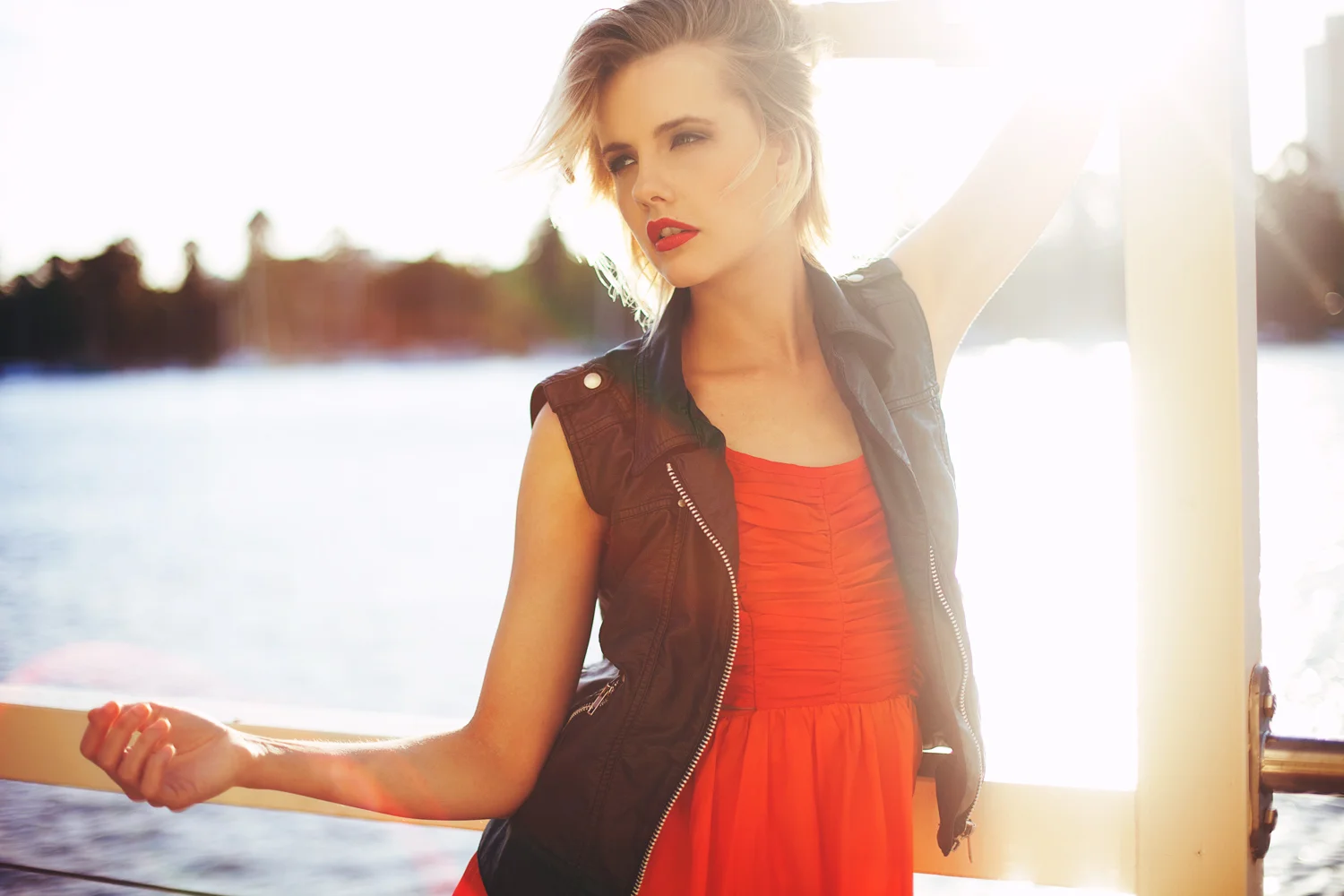 Brisbane, QLD Australia Fashion Photographer Stacey Russell || Fashion Photography Model Photoshoot || girl wearing red dress and leather jacket in front of sun and river backlit sun flare
