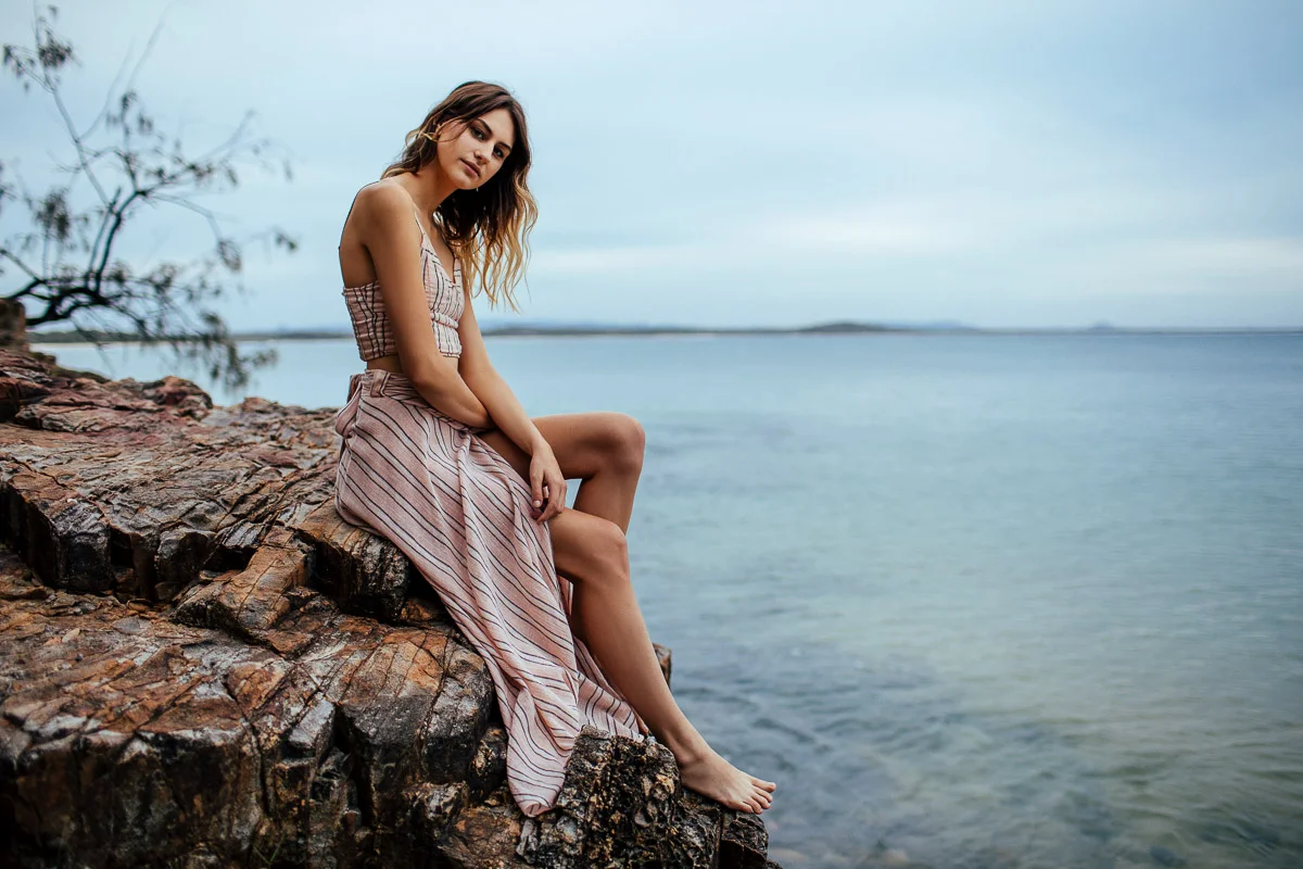 Brisbane Model Photographer Stacey Russell || Professional Australia Fashion Photography Modelling Photoshoot || Model portfolio image of girl sitting on beach cliffside in dress