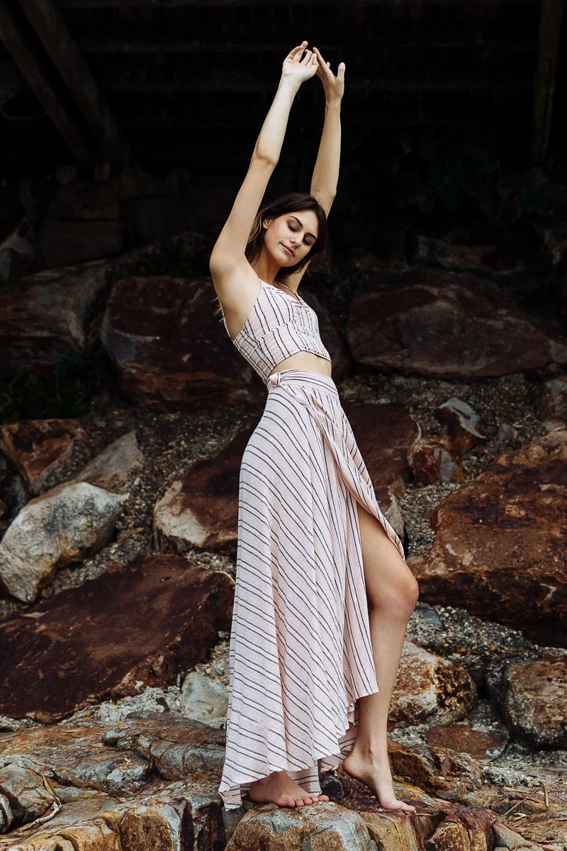 Brisbane Model Photographer Stacey Russell || Professional Australia Fashion Photography Modelling Photoshoot || Model portfolio image of girl in pink dress standing on rocks arms stretched upw (Copy)