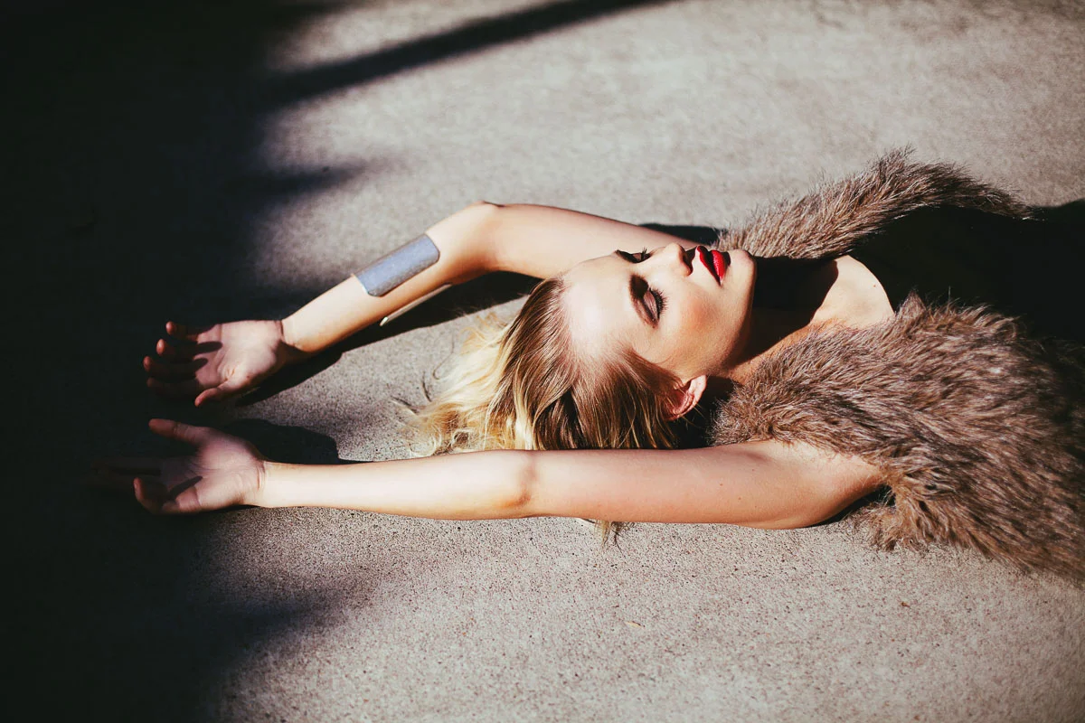 Brisbane Model Photographer Stacey Russell || Professional Australia Fashion Photography Modelling Photoshoot || Model portfolio image of blonde girl lying on ground arms behind head fur coat