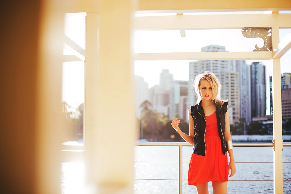 Brisbane Australia Fashion Photographer Stacey Russell || Fashion Photography Modelling Photoshoot || Model portfolio image of blonde girl wearing red dress and black jacket city backdrop