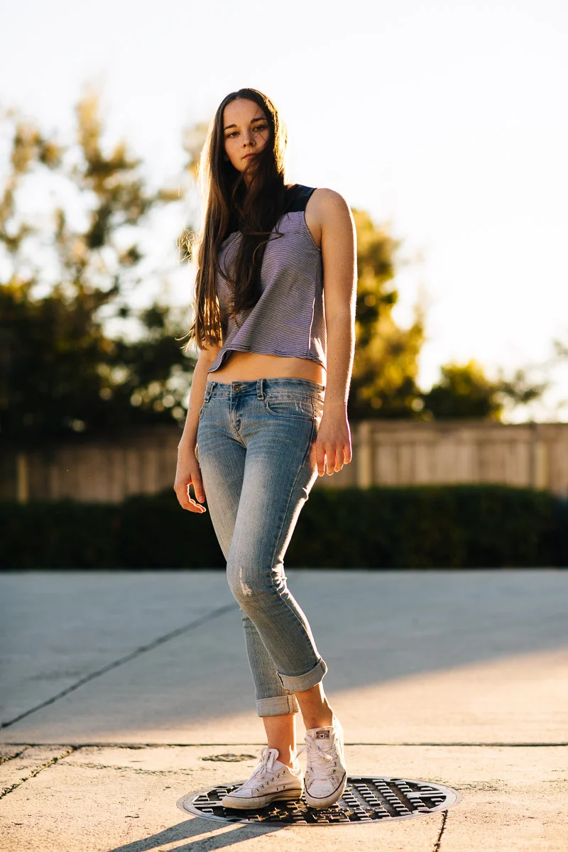 Brisbane Model Photographer Stacey Russell || Professional Australia Fashion Photography Modelling Photoshoot || Model portfolio image of long hair brunette standing on manhole wearing jeans (Copy)