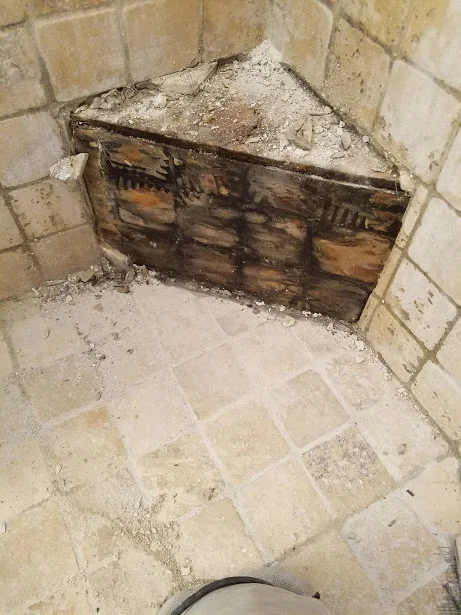 This corner bench was a wood box built on top of the shower pan with tile set directly to wood. This shower had a permanent stink to it, and it was coming from the swamp that was inside and all around this corner bench.