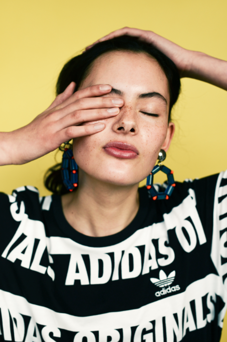Sharnee viste camiseta de ADIDAS ORIGINALS y pendientes de LARUICCI. 