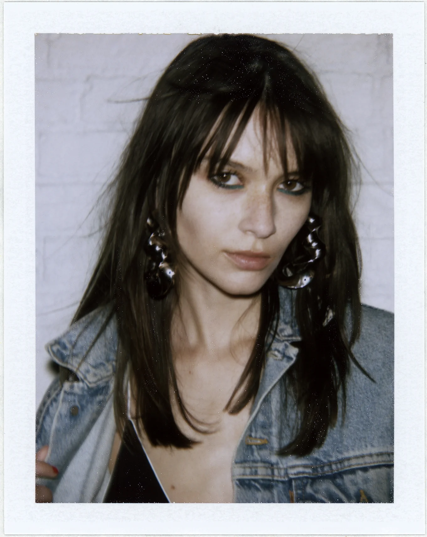 Chaqueta de mezclilla de LEVI'S, vestido de ADAM SELMAN y pendientes de ALTUZARRA. 