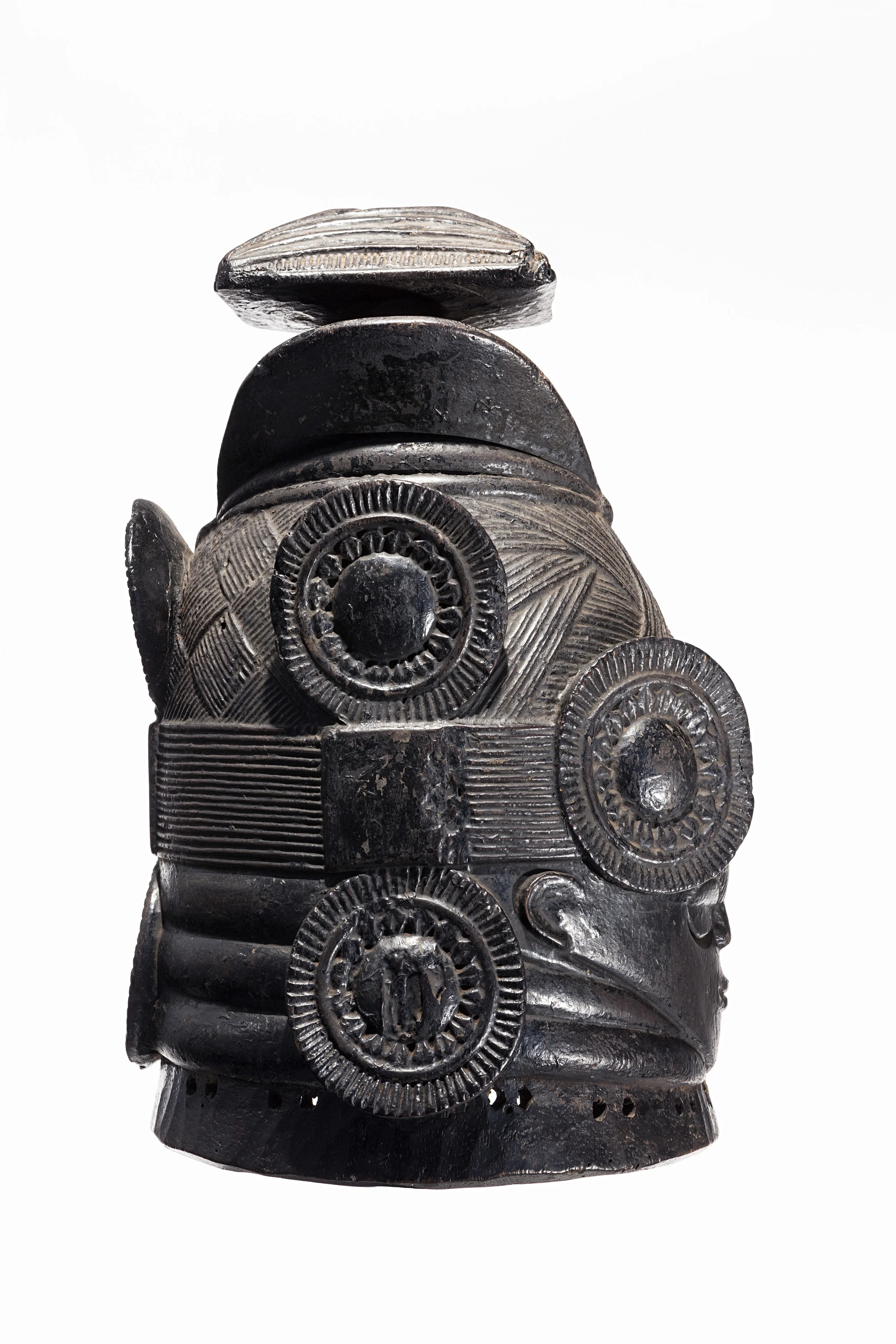MENDE, SIERRA LEONE, casco máscara de la sociedad femenina Sande, obra del Maestro de Nguabu. principios del siglo XX. Madera, pigmento, moneda de tres centavos del África Occidental Británica de 1943, 39,4 x 24 x 26.