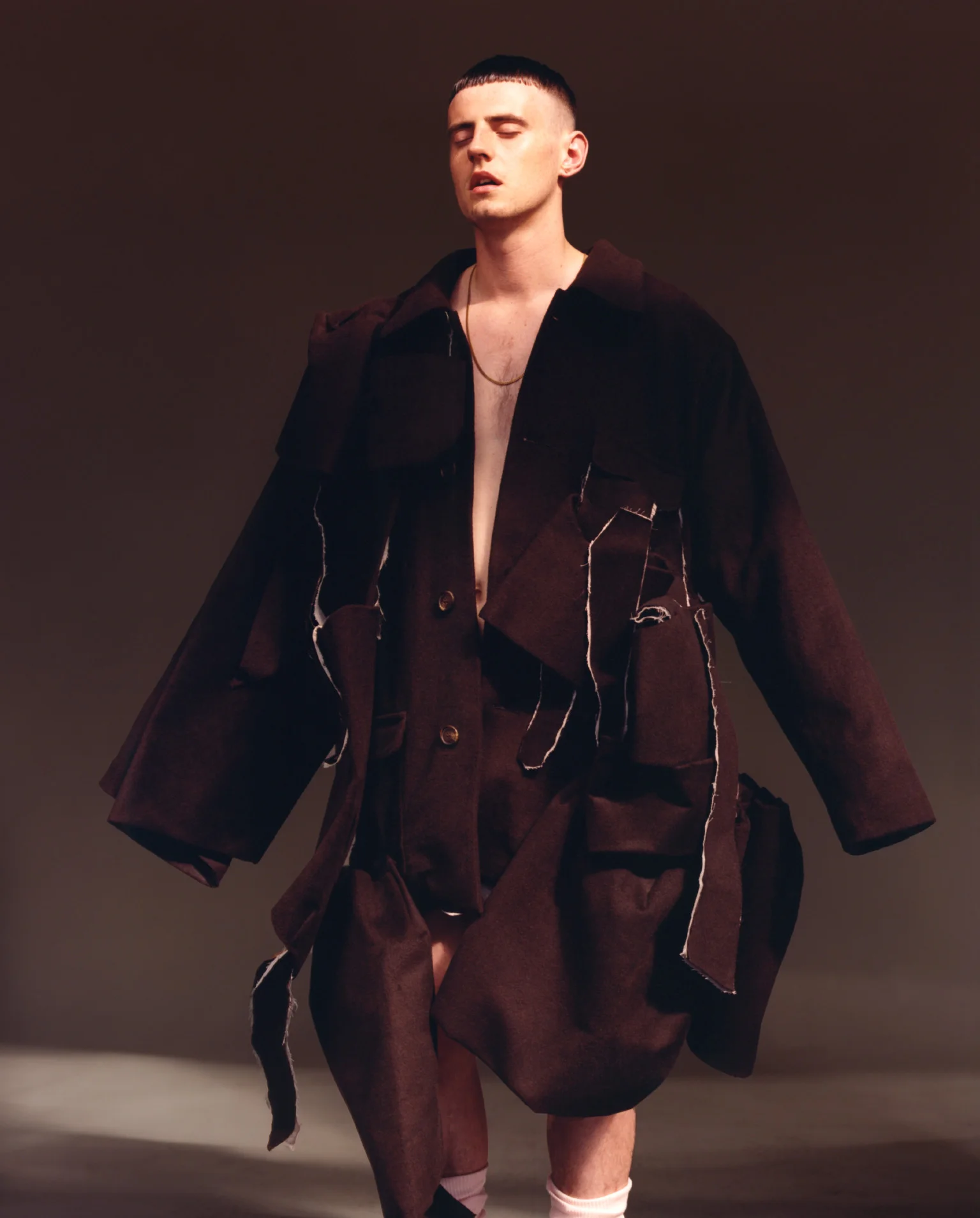 Cae viste abrigo de CHARLES JEFFREY LOVERBOY, calentadores de CAPEZIO y su propia cadena de oro. 