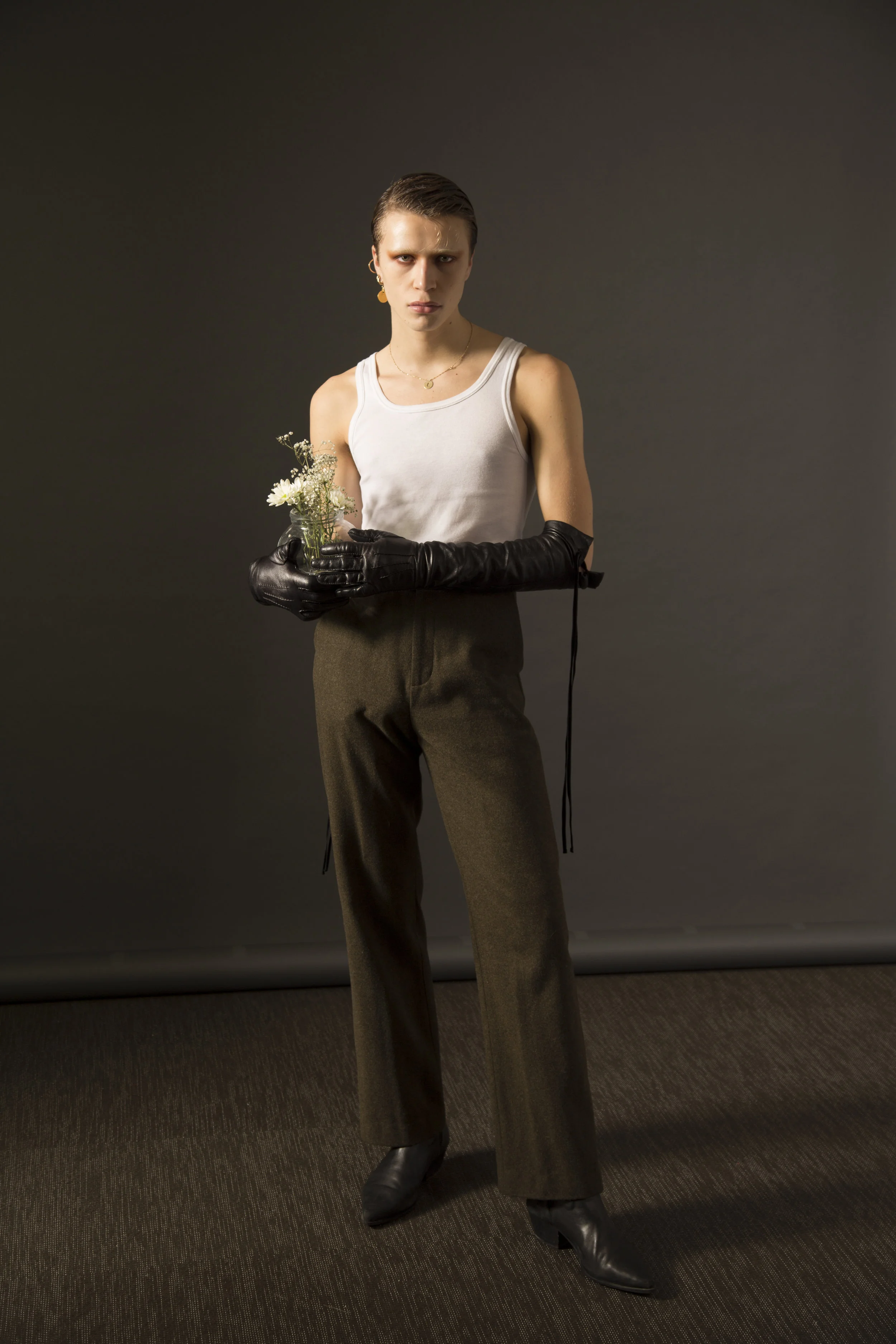 Camiseta sin mangas de LEMAIRE , guantes de ANN DEMEULEMEESTER , pantalón de JOSEPH y collar de CHLOÉ .
