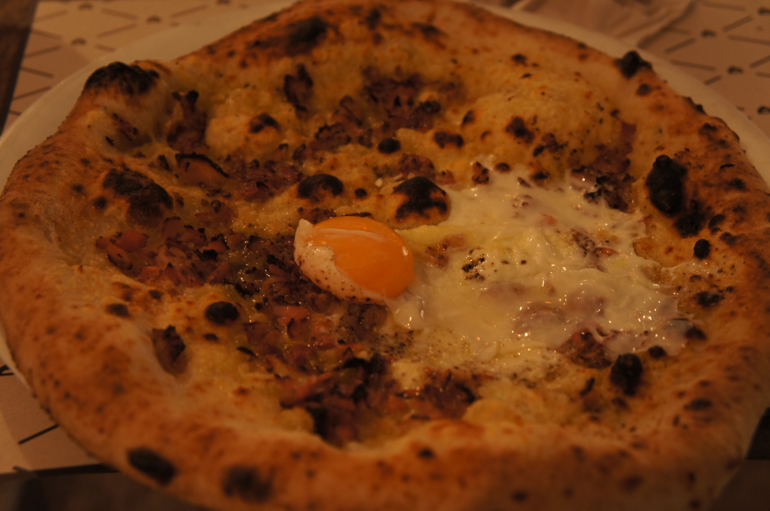 Um dos pratos foi a pizza Carbonara. Ela é um sabor super fotogênico, não é? Essa versão leva pancetta e pimenta-do-reino, que dá um toque diferente. As pizzas são em tamanho individual. 