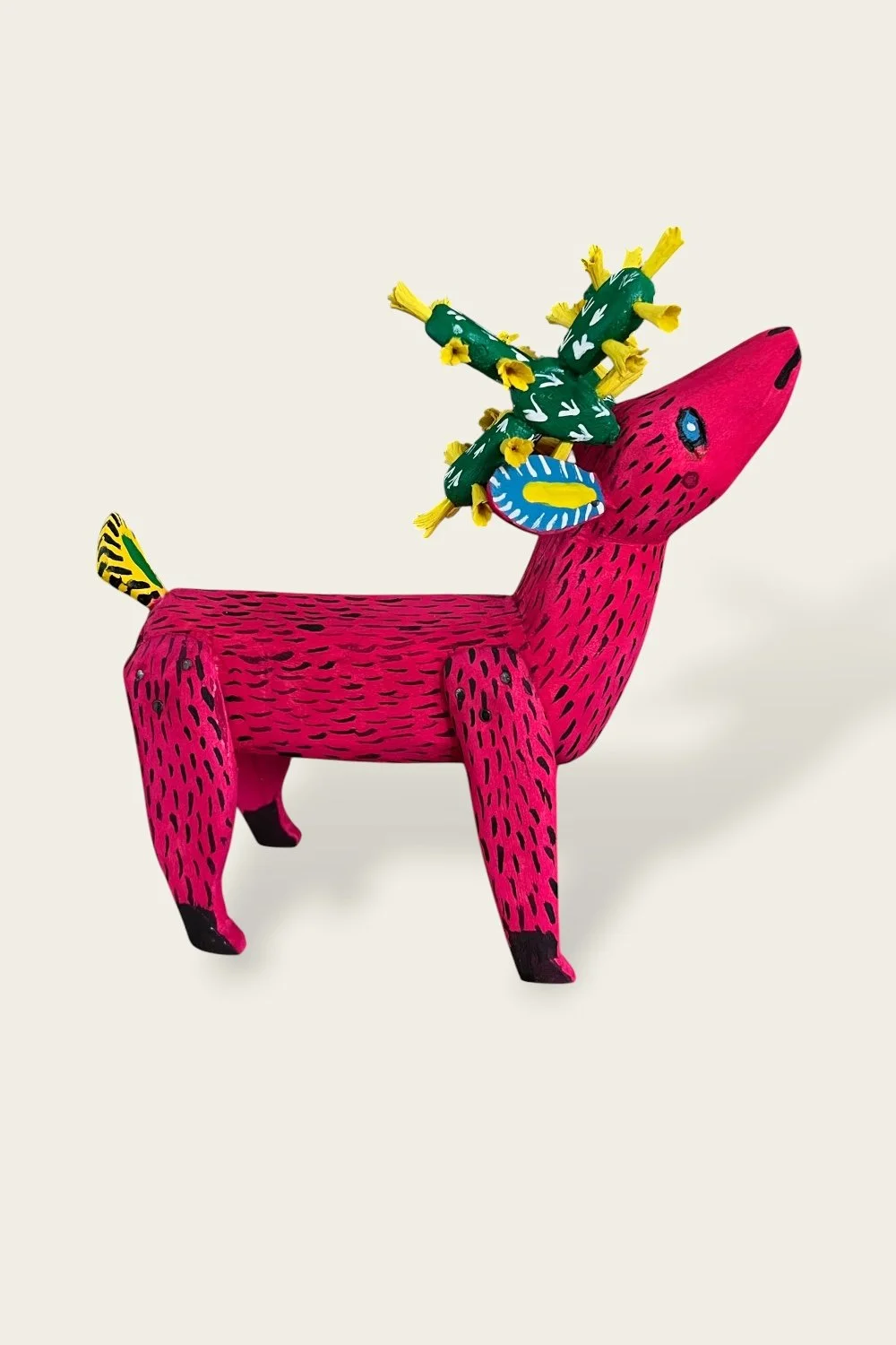 Pink carved wooden deer from Oaxaca with cactus antlers