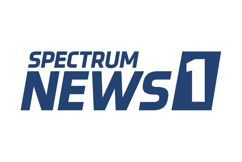 Spectrum News 1 logo in blue text on a white background.