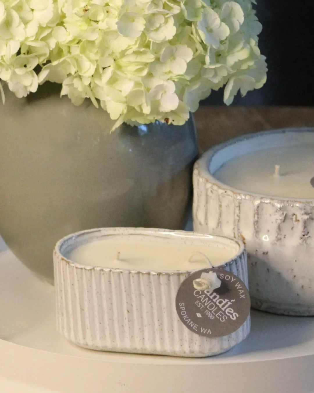 This oval best-seller is back!
Freshen up your home this spring with perfectly scented candles poured in Spokane. Check out all the spring candles hitting stores including...

⟐ Country Porch Swing
A fresh flower garden after a spring rain with flora