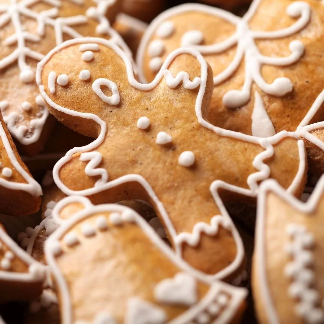 Close-up of decorated gingerbread cookies with white icing on holiday-themed cookies, including a gingerbread man.
