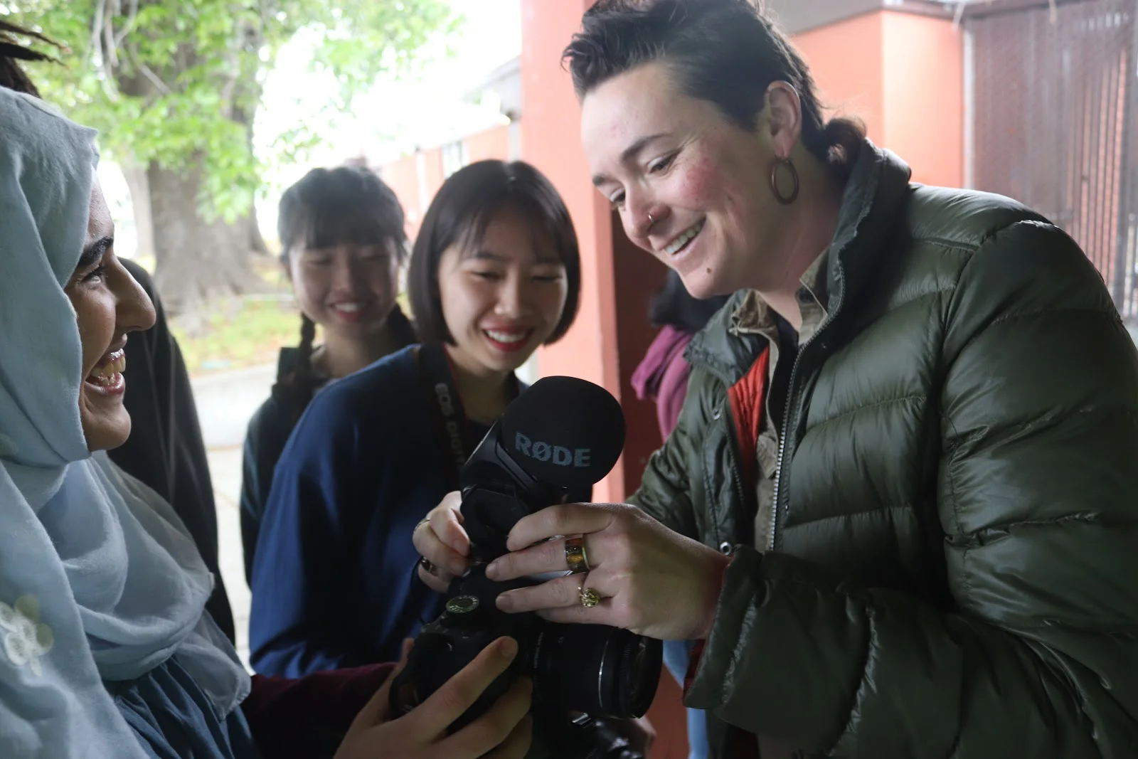 Mallory showing her students around a camera at Oakland International High School