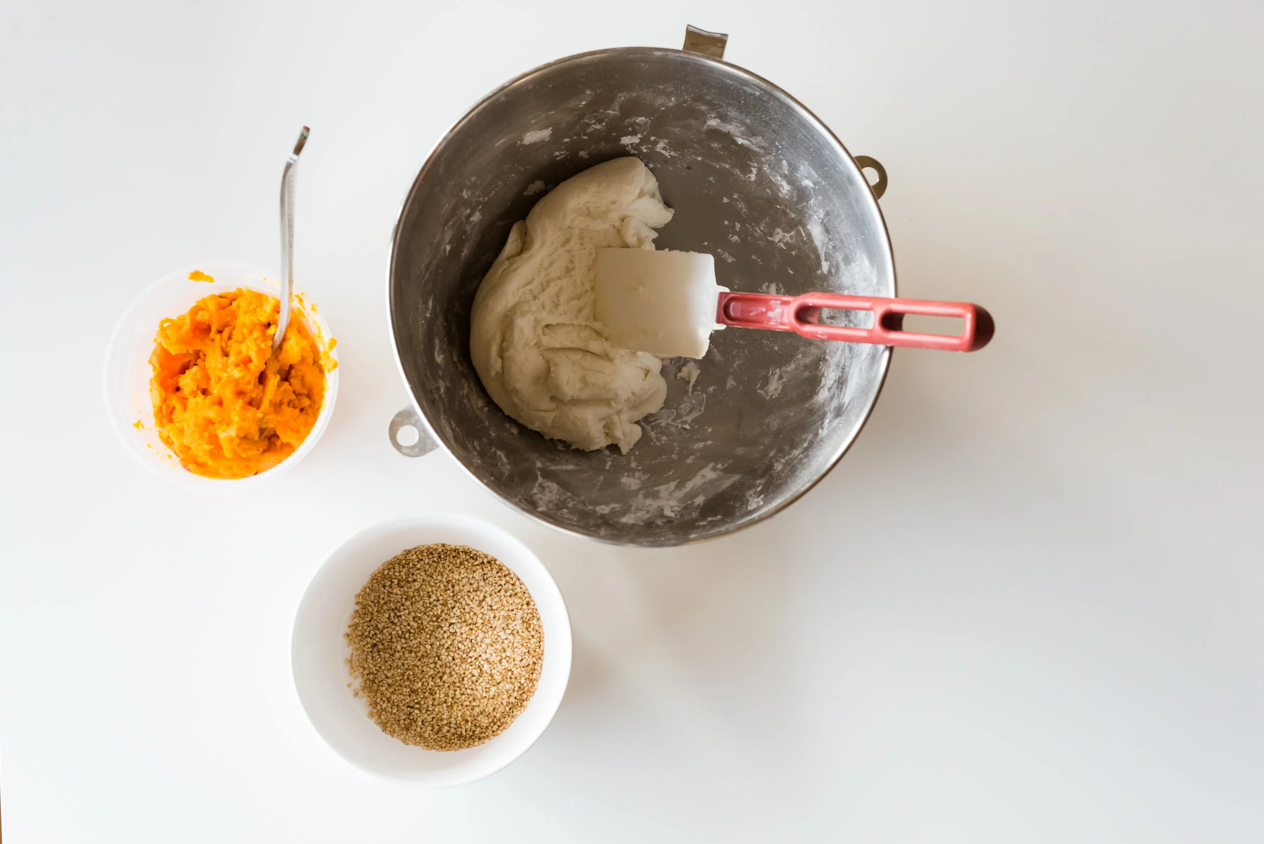 Dissolve sugar into water and combine this mixture with glutinous rice flour to make your dough. Also pictured: mashed sweet potato and sesame seeds.