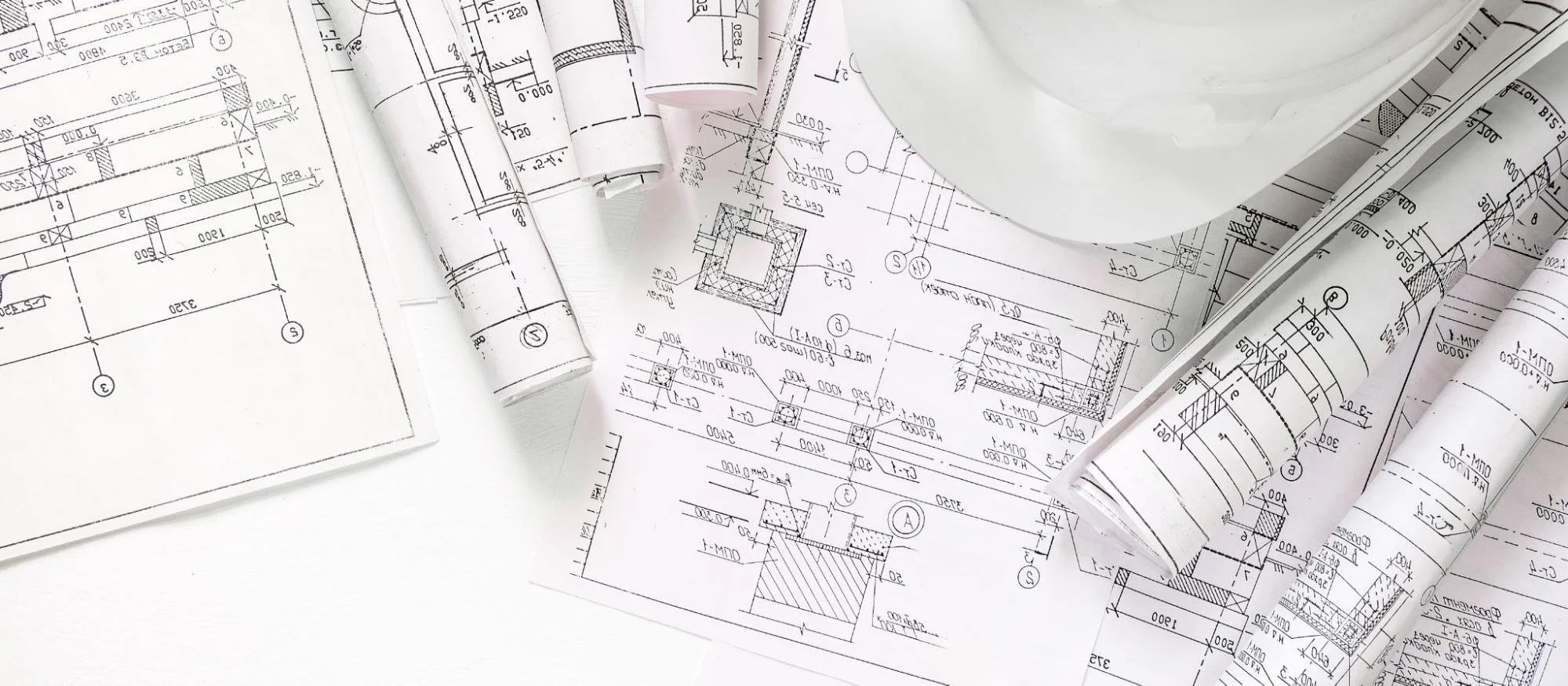 Construction hat on a pile of as-built drawings.