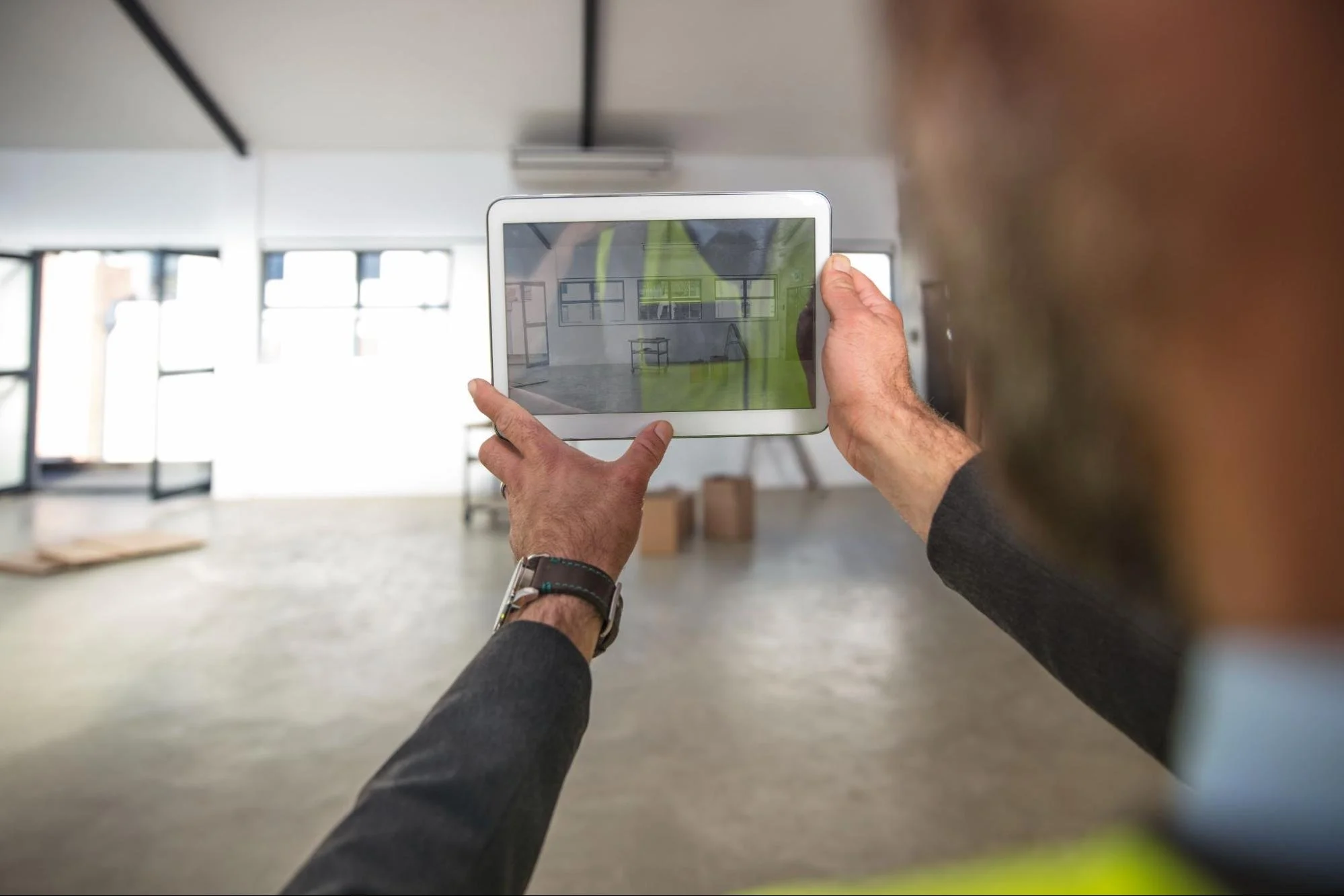 An architect reviewing an interactive floor plan on a tablet for commercial building survey management