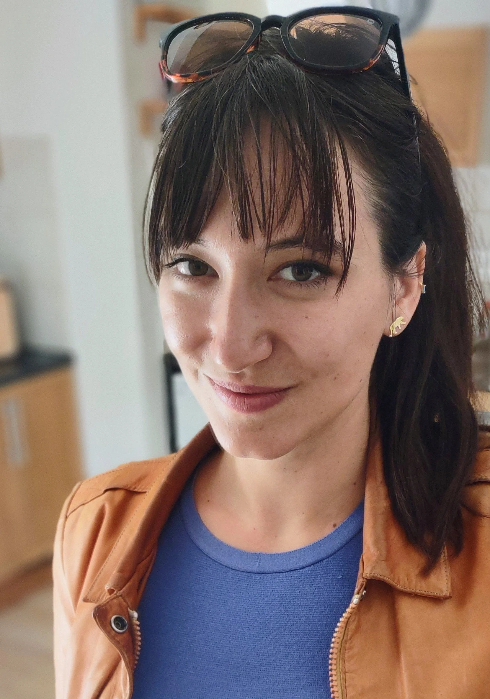 Headshot of Sophia Zaia smiling with dark hair and bangs.