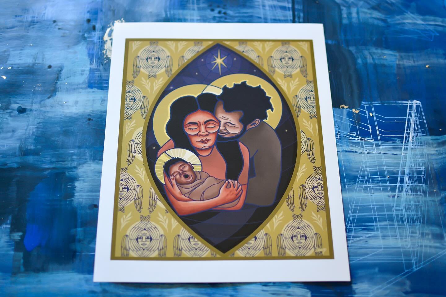 The golden field surrounding the mandorla is filled with my interpretation of the six-winged seraphim from early Christian art, representing the heavenly hosts filling the air with tidings of peace (imaged by olive branches). A seven pointed star han