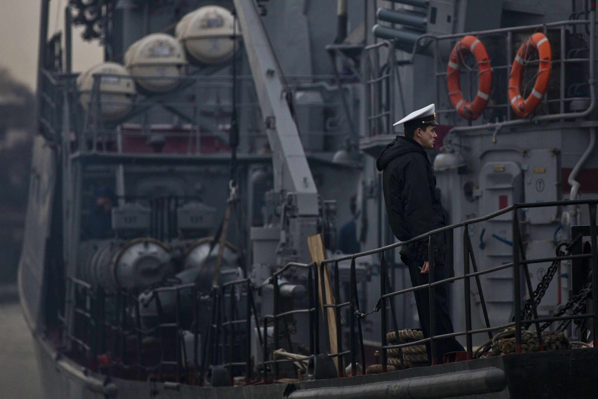  Ukrainian sailor is seen smocking on board of his vessel as it is blocked by Russian ships near Sevatopol 