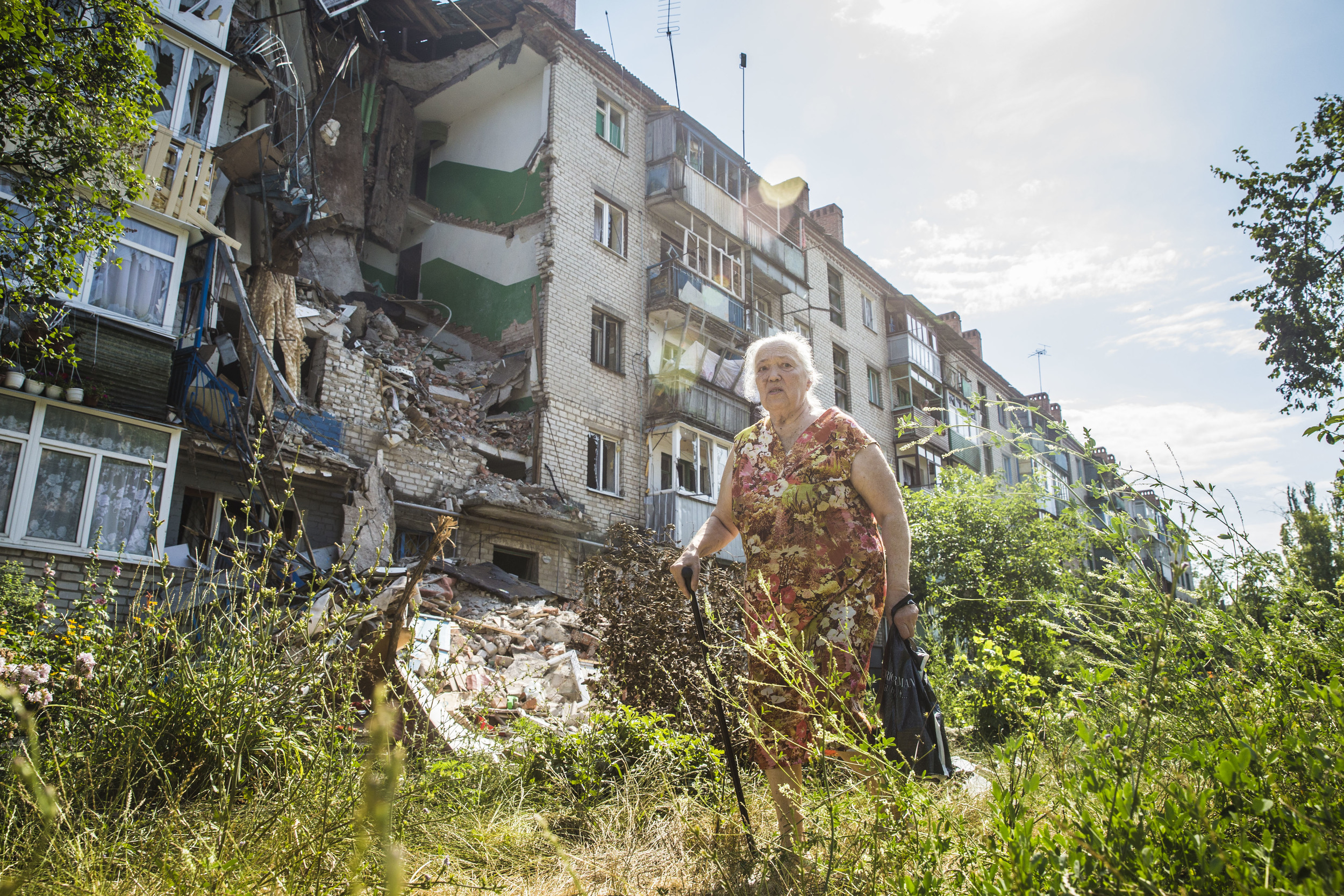  Woman passes by a destroyed building in Sloviansk 