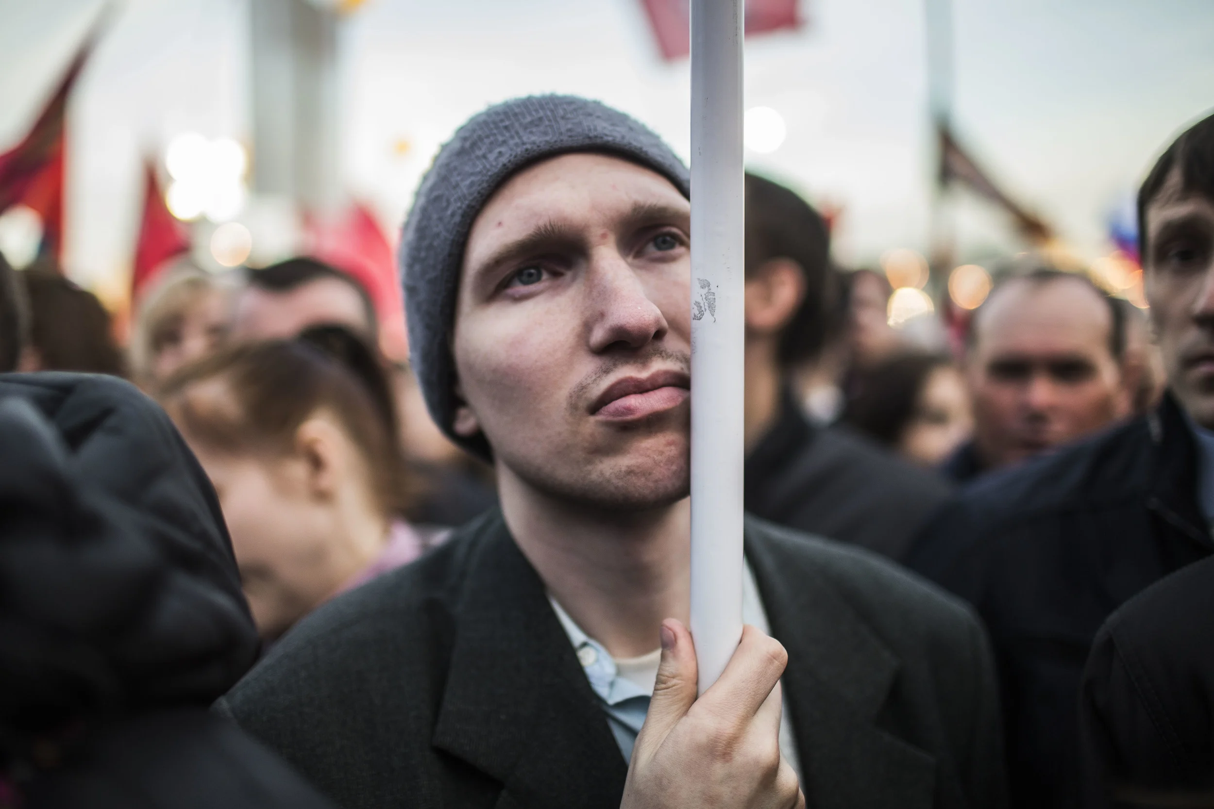 An attendee to a rally celebrating an anniversary of Crimea annexation listens to president Putin's speech. Moscow, March 14, 2015