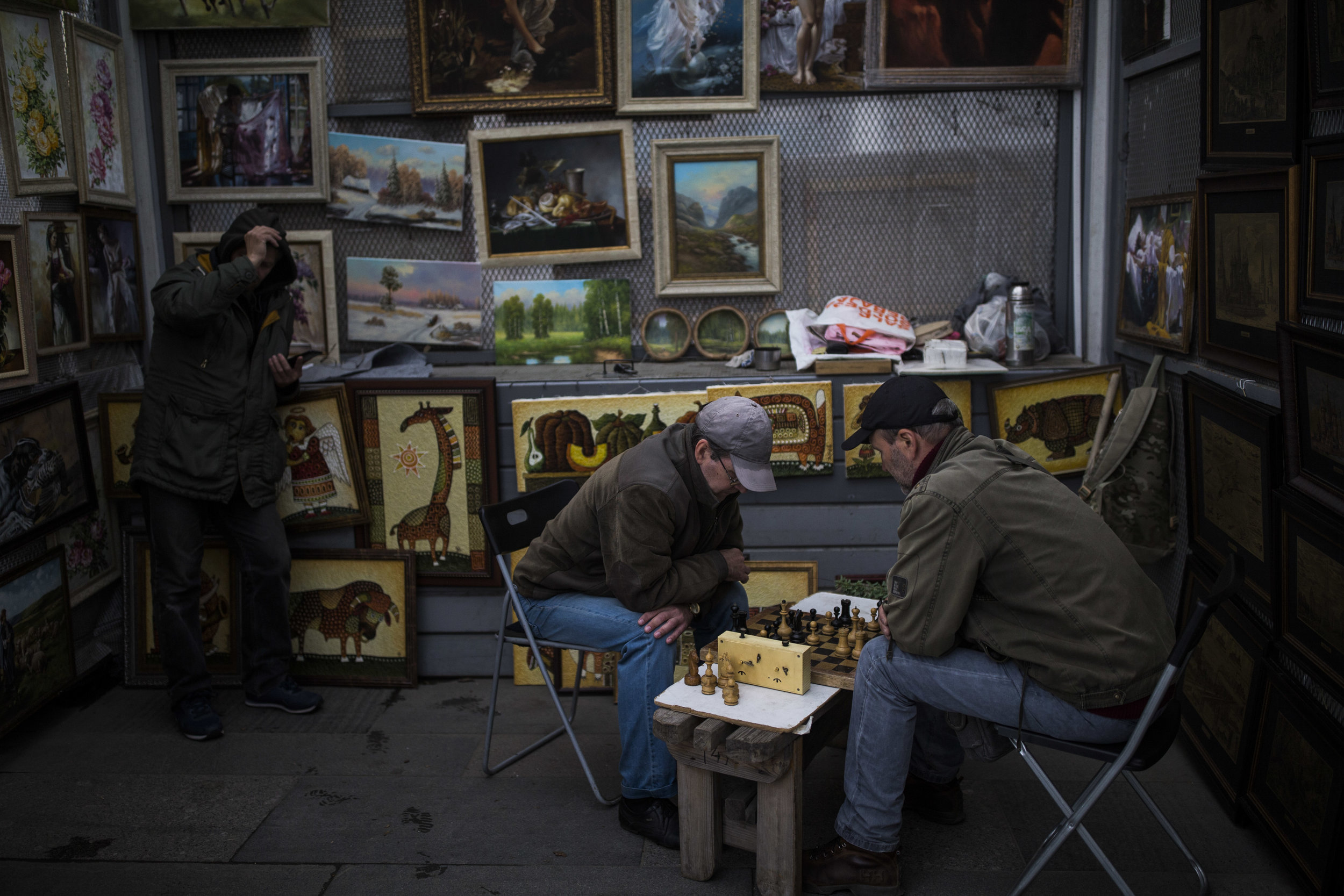 Artists are playing chess as they hide from the rain at vernissage next to Tretyakov gallery in Moscow