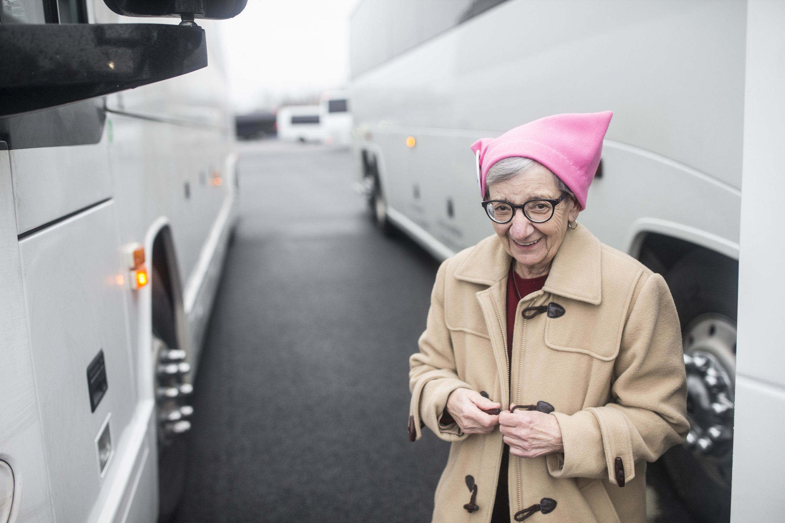  A woman looks into a camera as she gets off a bus that brought her and thousands other women to D.C. for the Women's March 